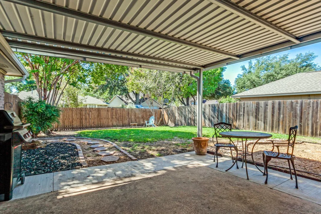 Expansive covered patio with corrugated metal roof providing year-round outdoor living space