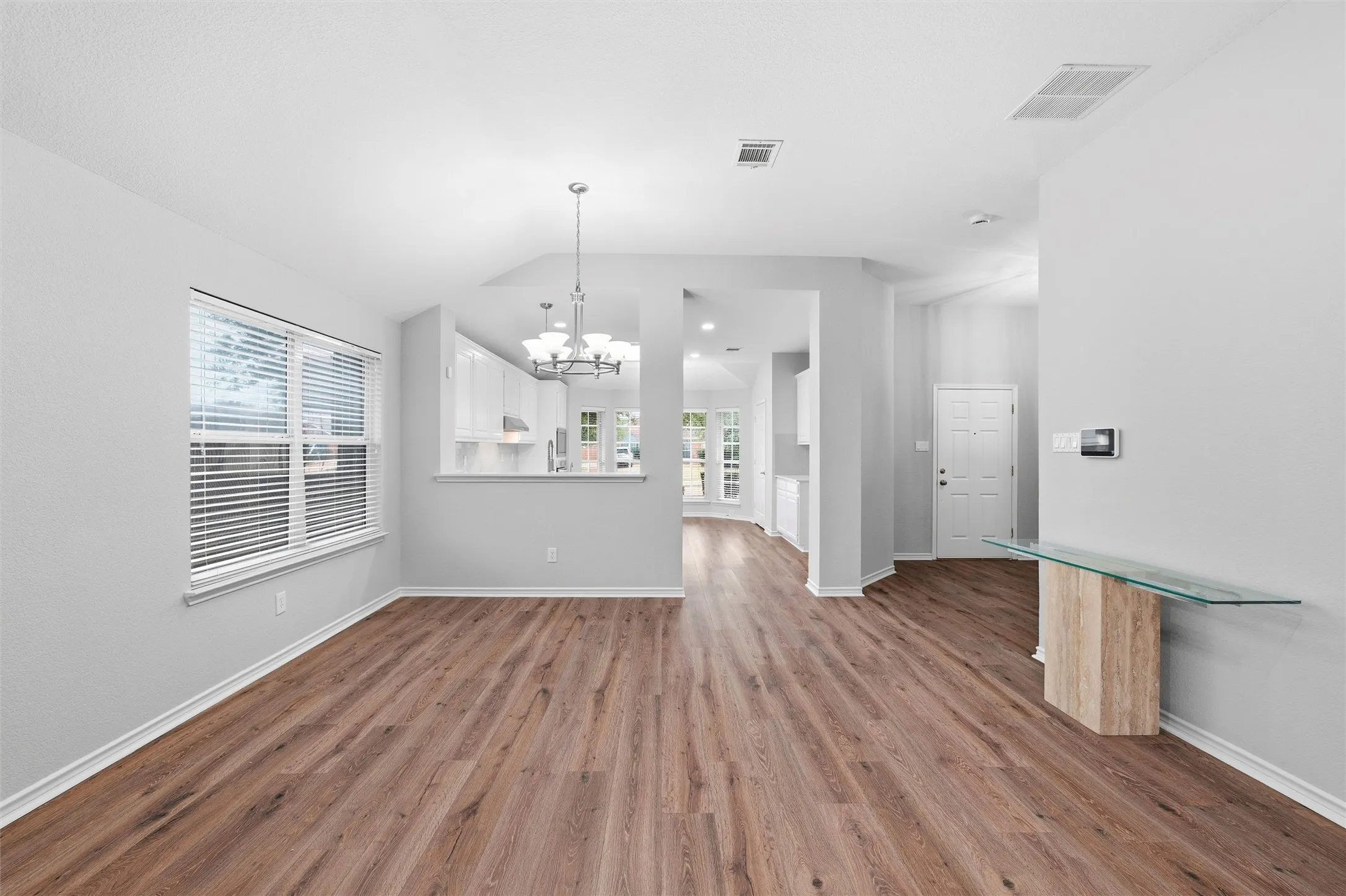 Dedicated dining space highlighted by a modern chandelier, large window, and easy access to the kitchen—ideal for both casual meals and gatherings.