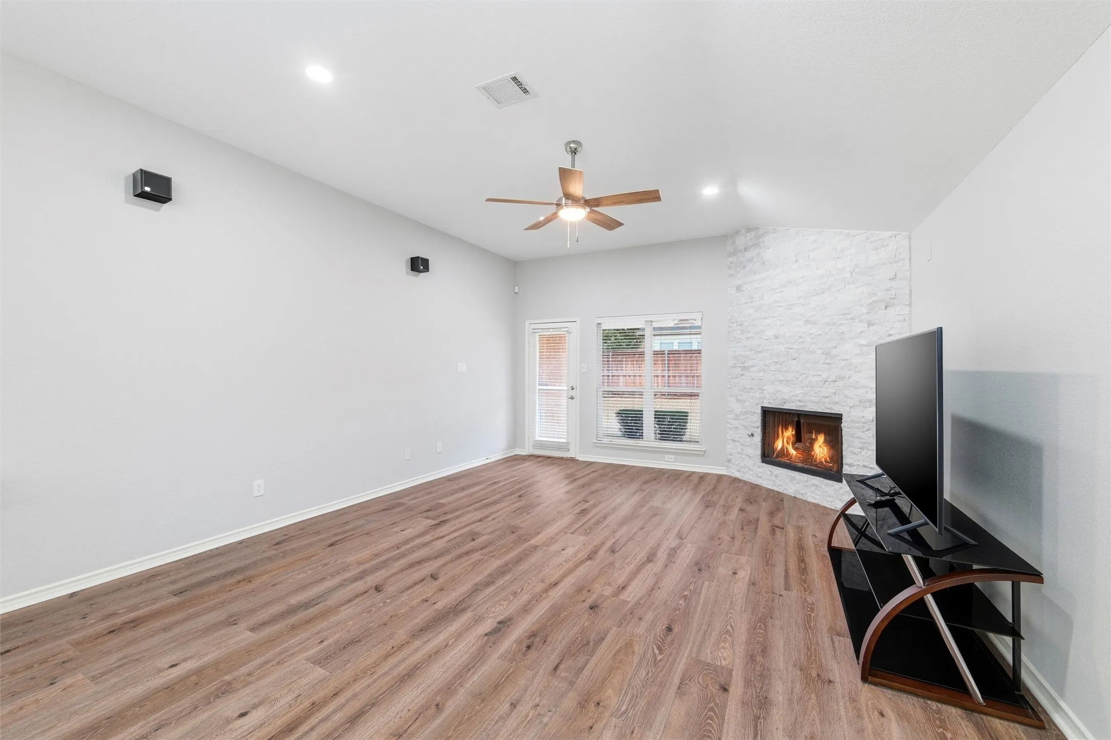 The living area features an updated fireplace surround, recessed lighting, and access to the back patio.
