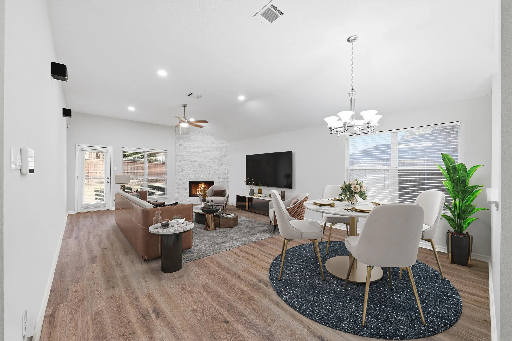 Freshly updated and move-in ready, the open-concept living room features soaring ceilings, new luxury vinyl plank flooring, and a stunning floor-to-ceiling stone fireplace.