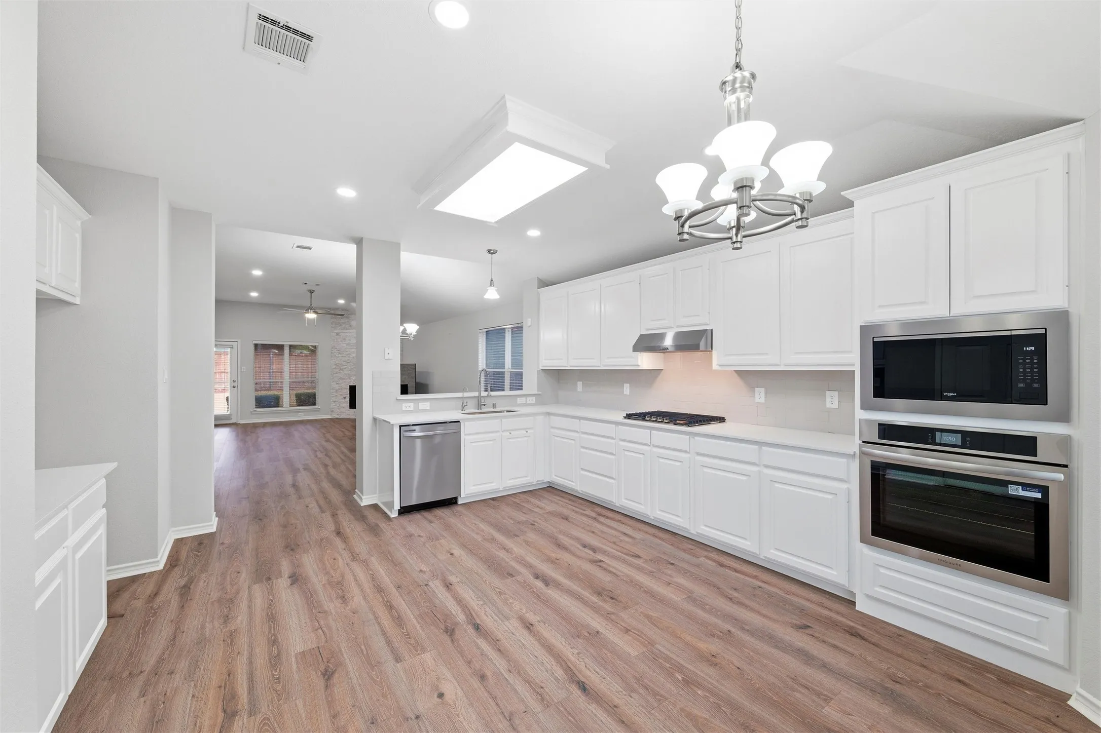 The updated kitchen featuring ample cabinetry, gas cooktop, built-in oven and microwave, and a clean, timeless color palette.