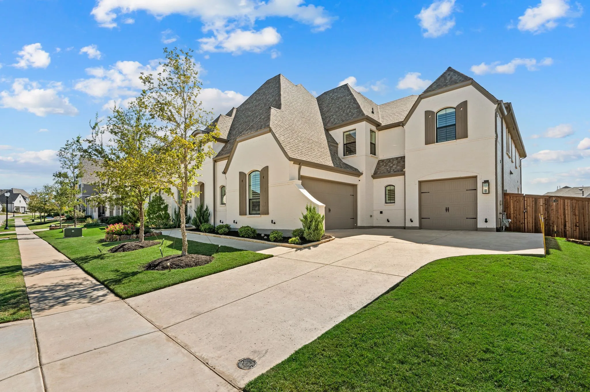 Stucco exterior with multiple gabled rooflines, arched window details, and decorative shutters