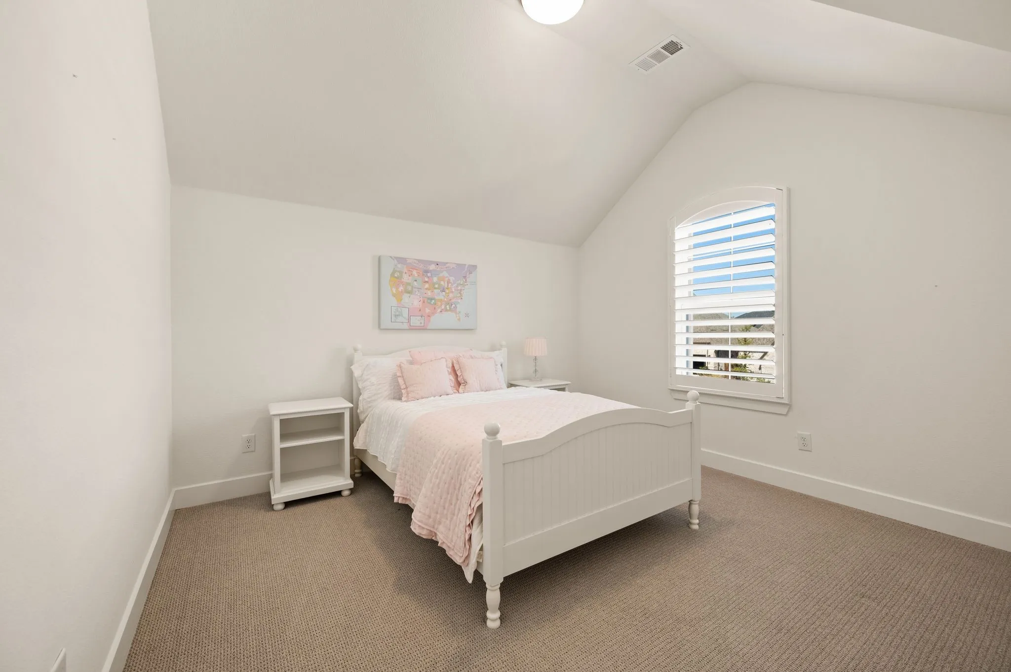 Vaulted ceiling featuring a recessed light fixture, arched window with plantation shutters, and light-toned wall-to-wall carpeting