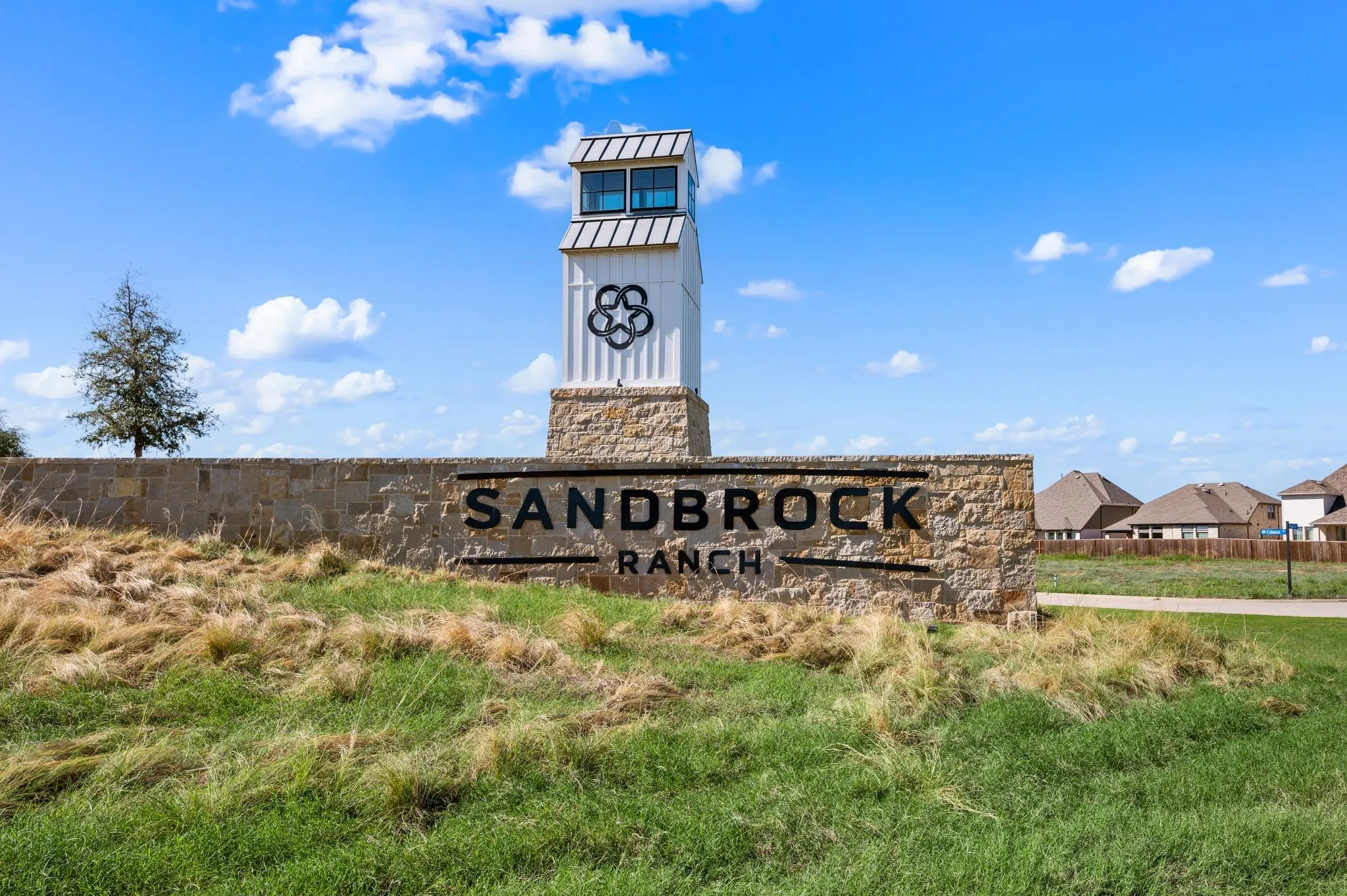 Stone entryway wall featuring integrated "SANDBROCK RANCH" lettering