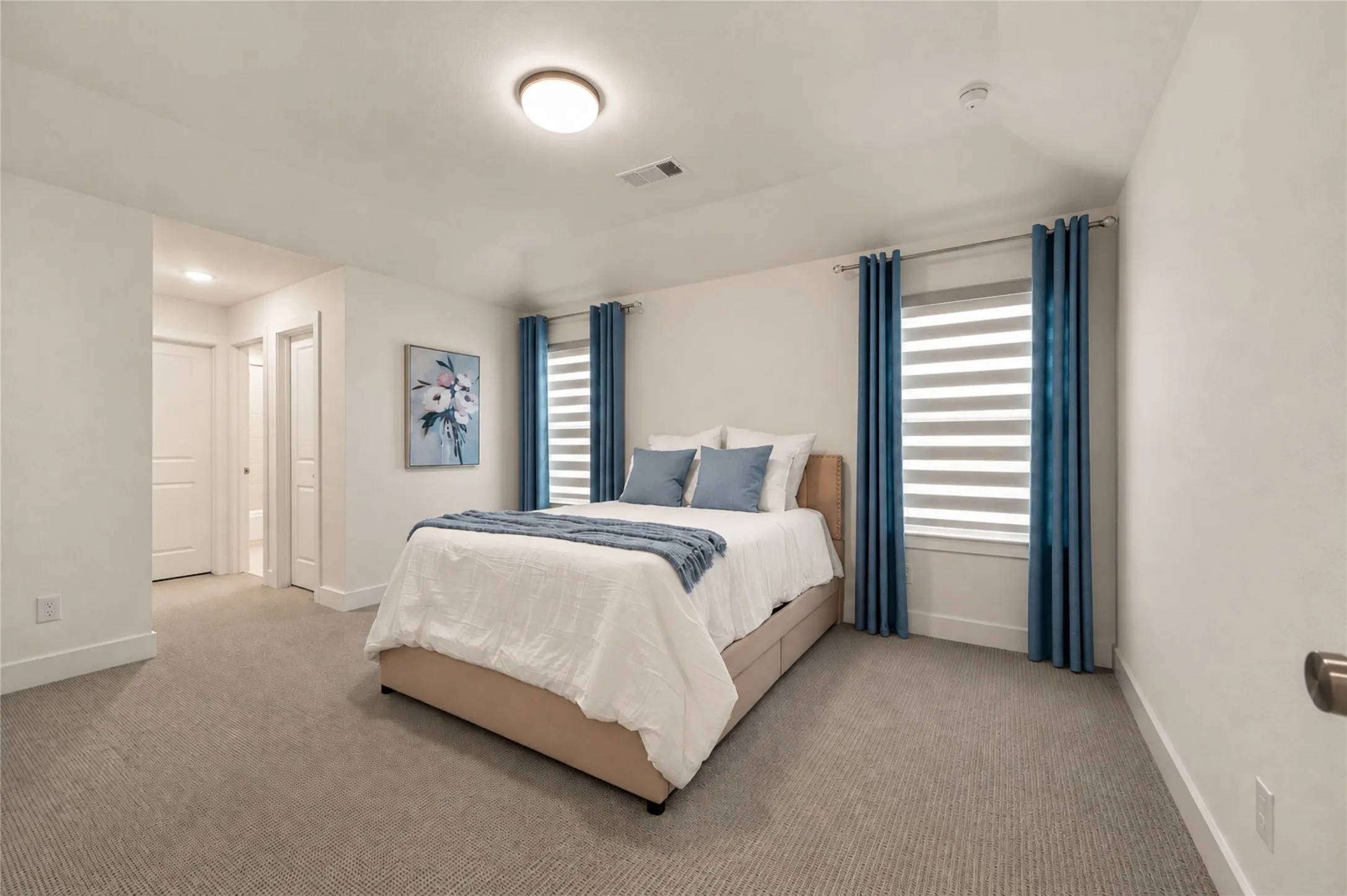 Light gray carpeting, white walls, and a flush-mount ceiling light fixture