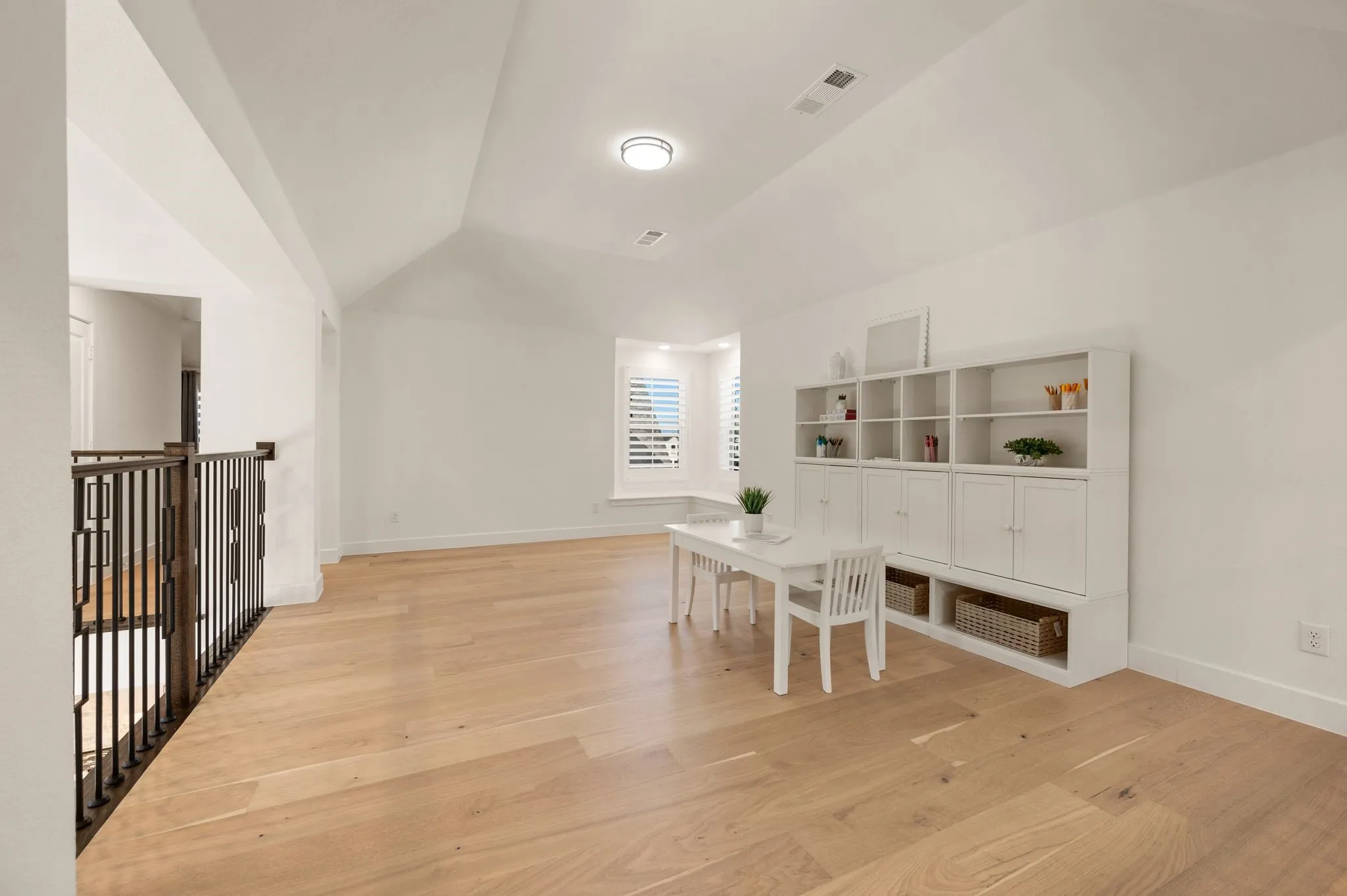 Bright, open upstairs Game room featuring wood-finish flooring, a vaulted ceiling, and a built-in window seat