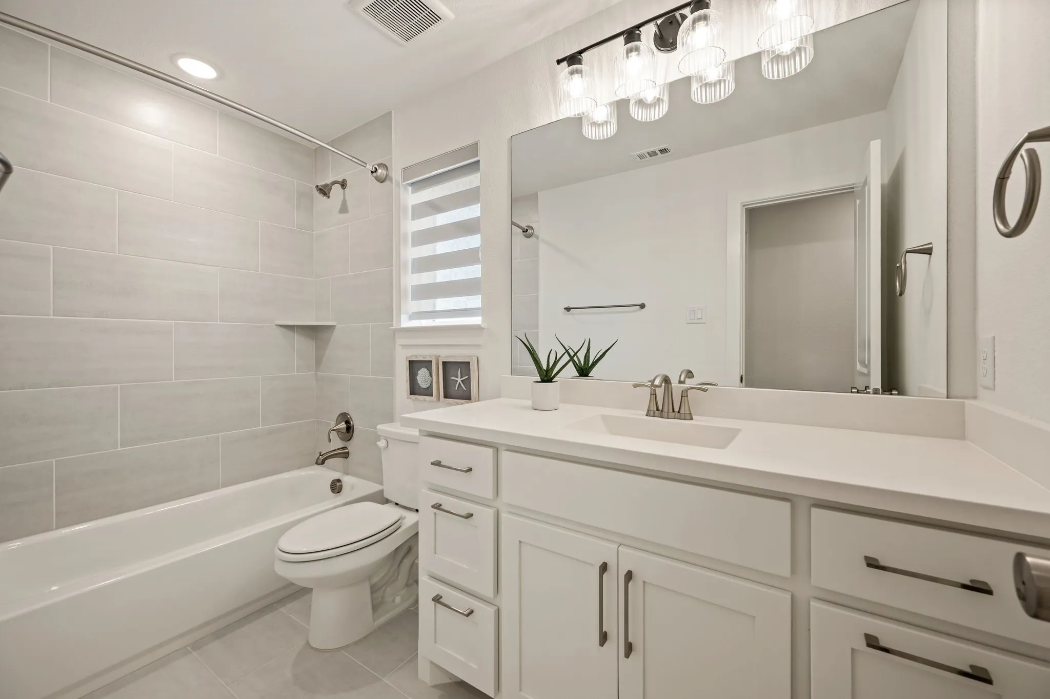 White vanity with a single basin sink and brushed nickel faucet