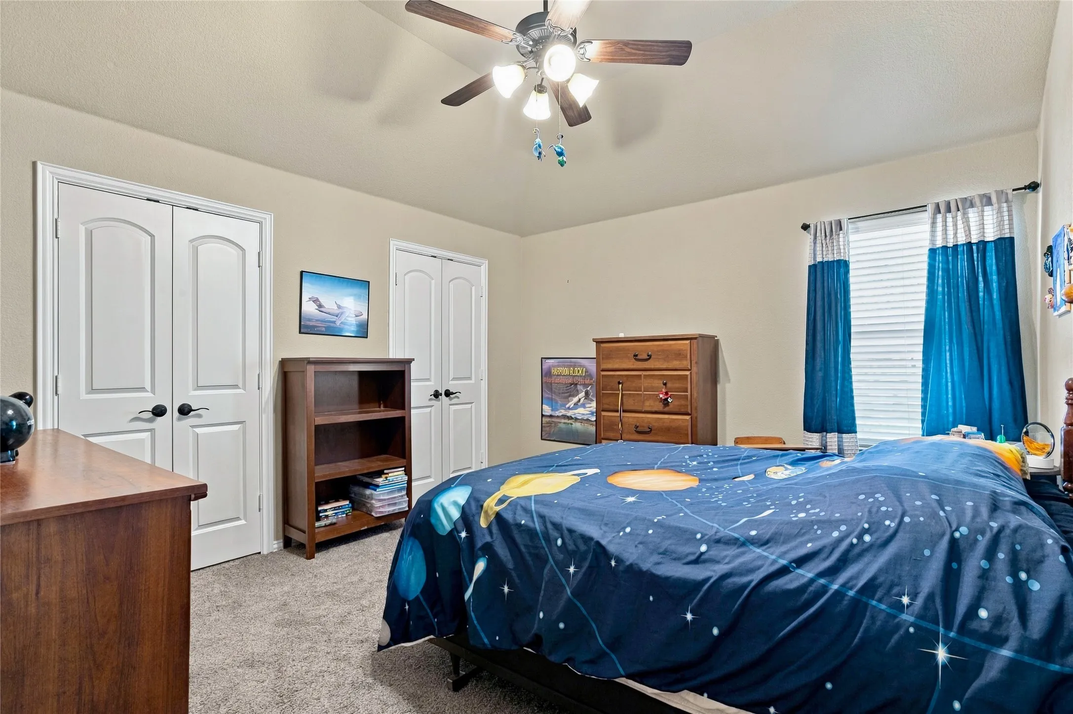 Comfortable secondary bedroom with ceiling fan and natural light.