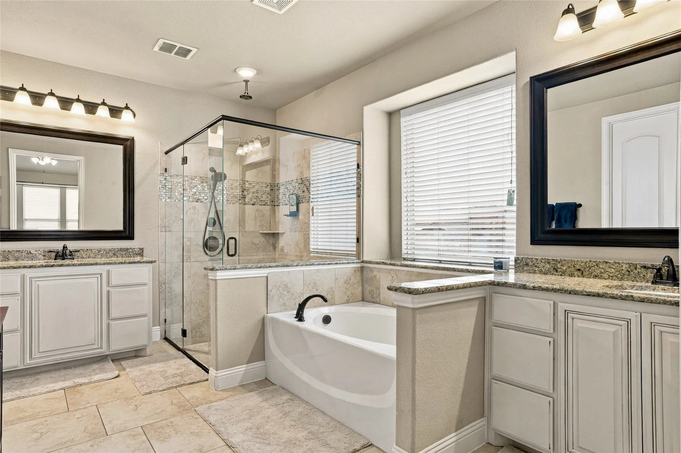 Primary bathroom featuring dual sinks and ample vanity storage.