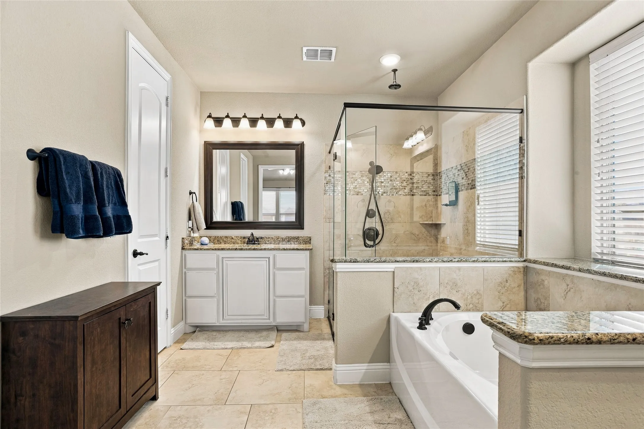 Spacious bathroom with separate vanities and a relaxing atmosphere.