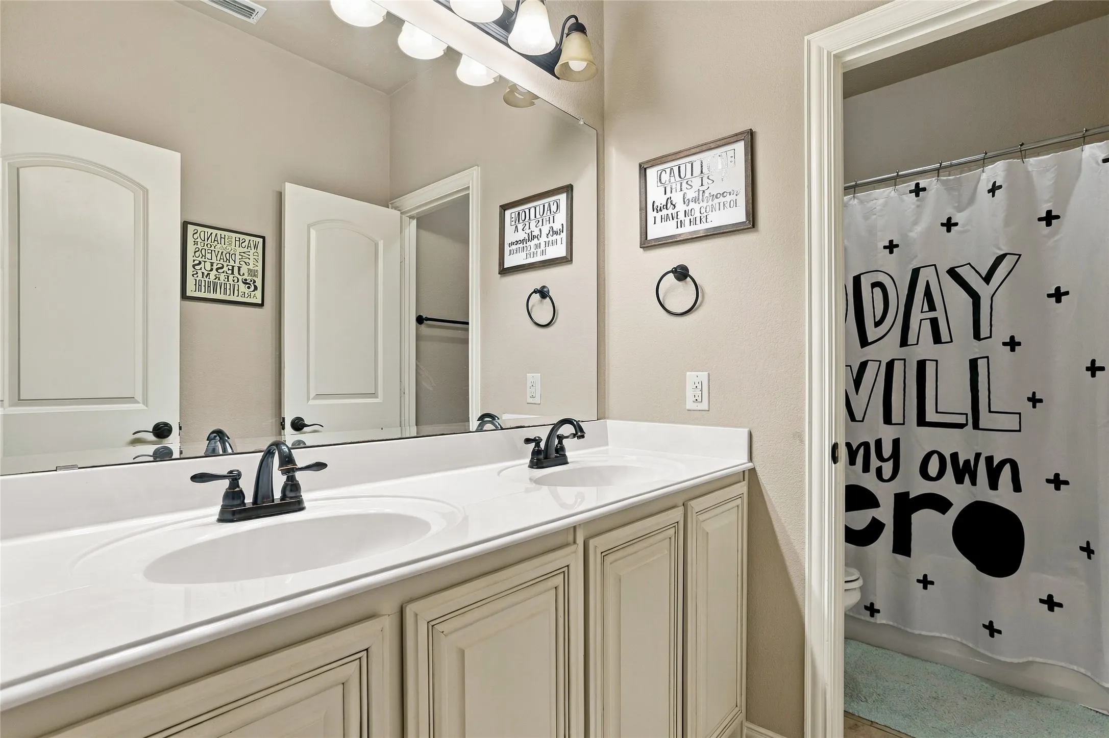 Bathroom with dual sinks, generous counter space, and storage.