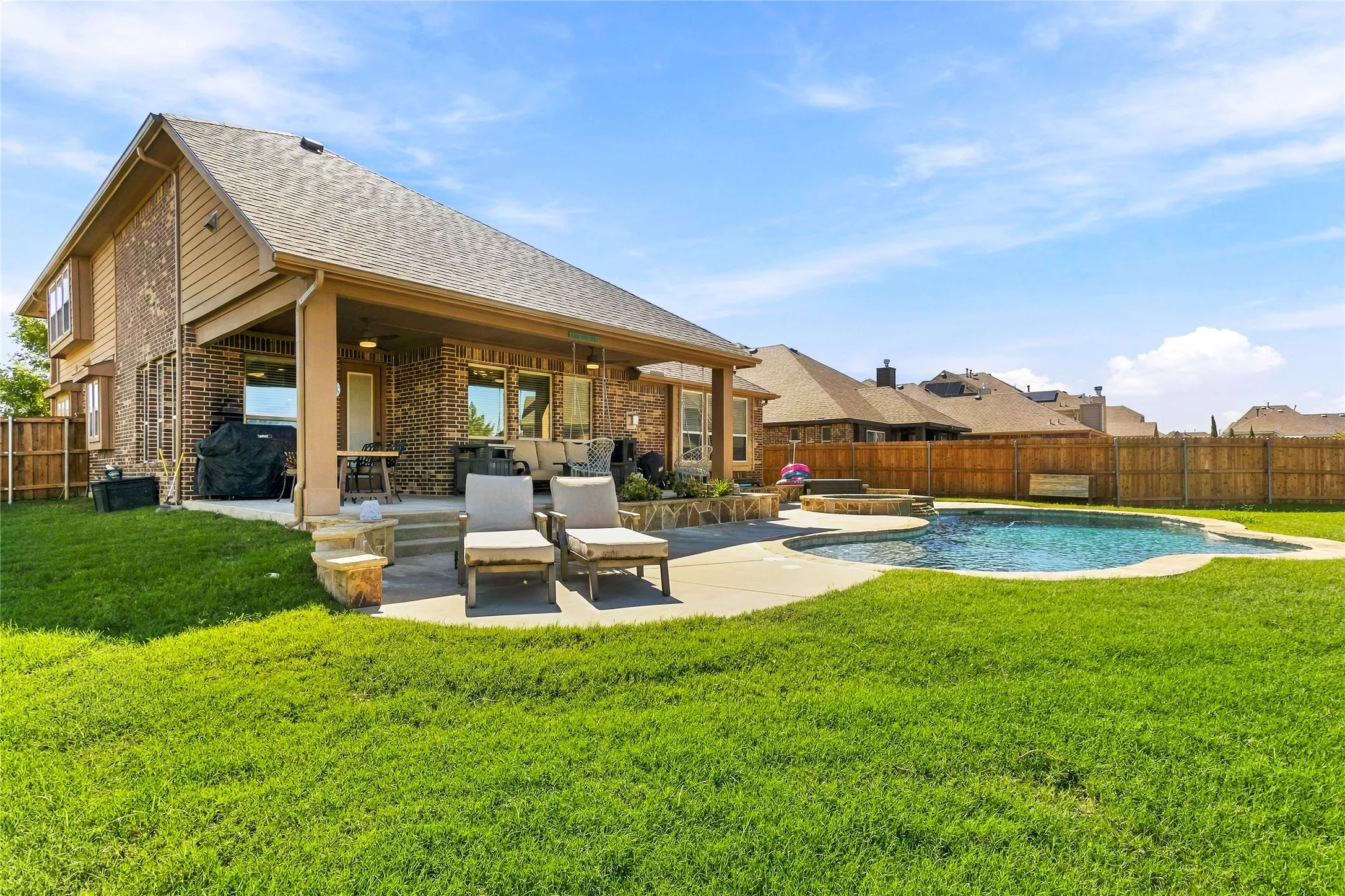Rear exterior showcasing the covered patio and spacious yard.