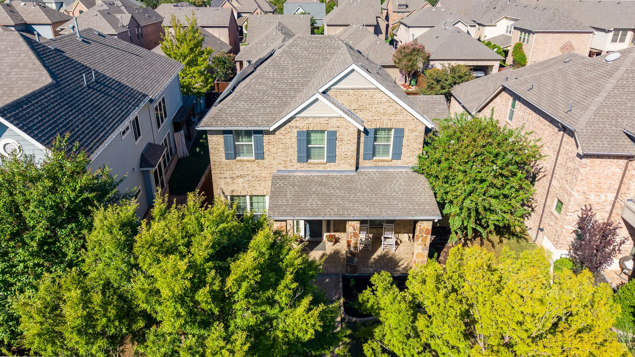 Brick exterior with stone accents, covered front porch, and shutters