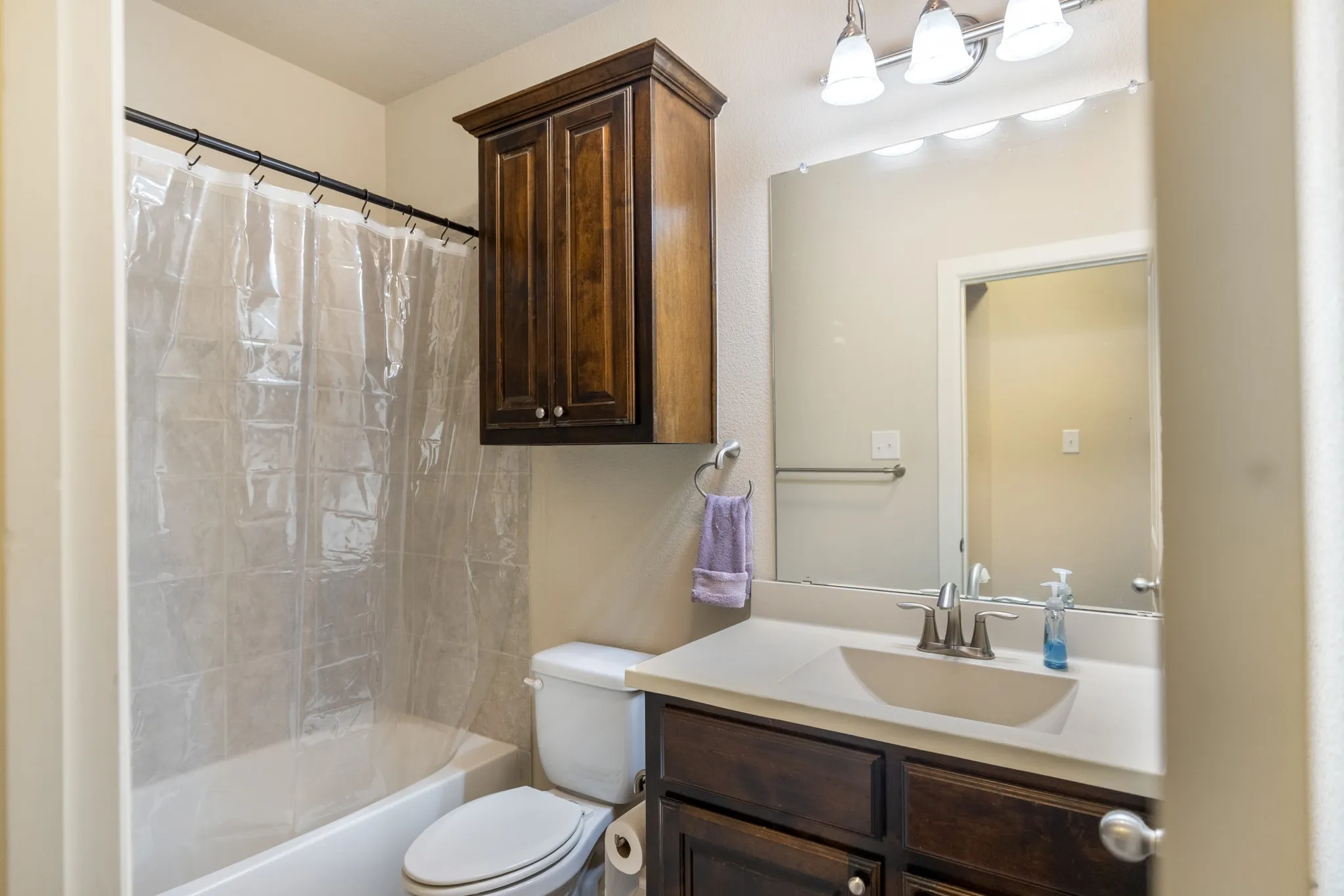 Bathroom with a vanity featuring a built-in sink, a wall-mounted mirror, and overhead lighting