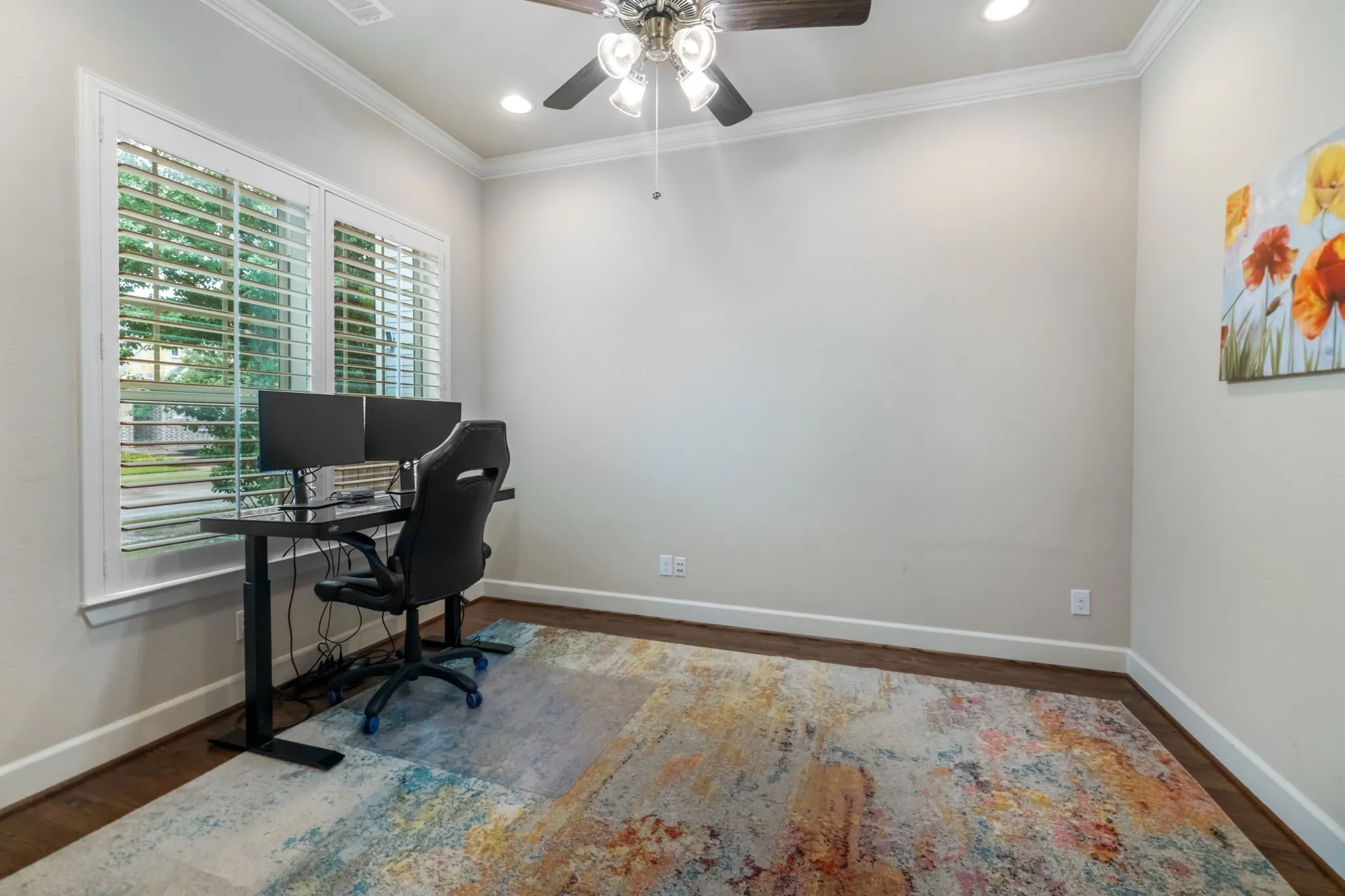 First floor. Hardwood-style flooring with white trim, a ceiling fan with integrated lighting, and recessed ceiling lights