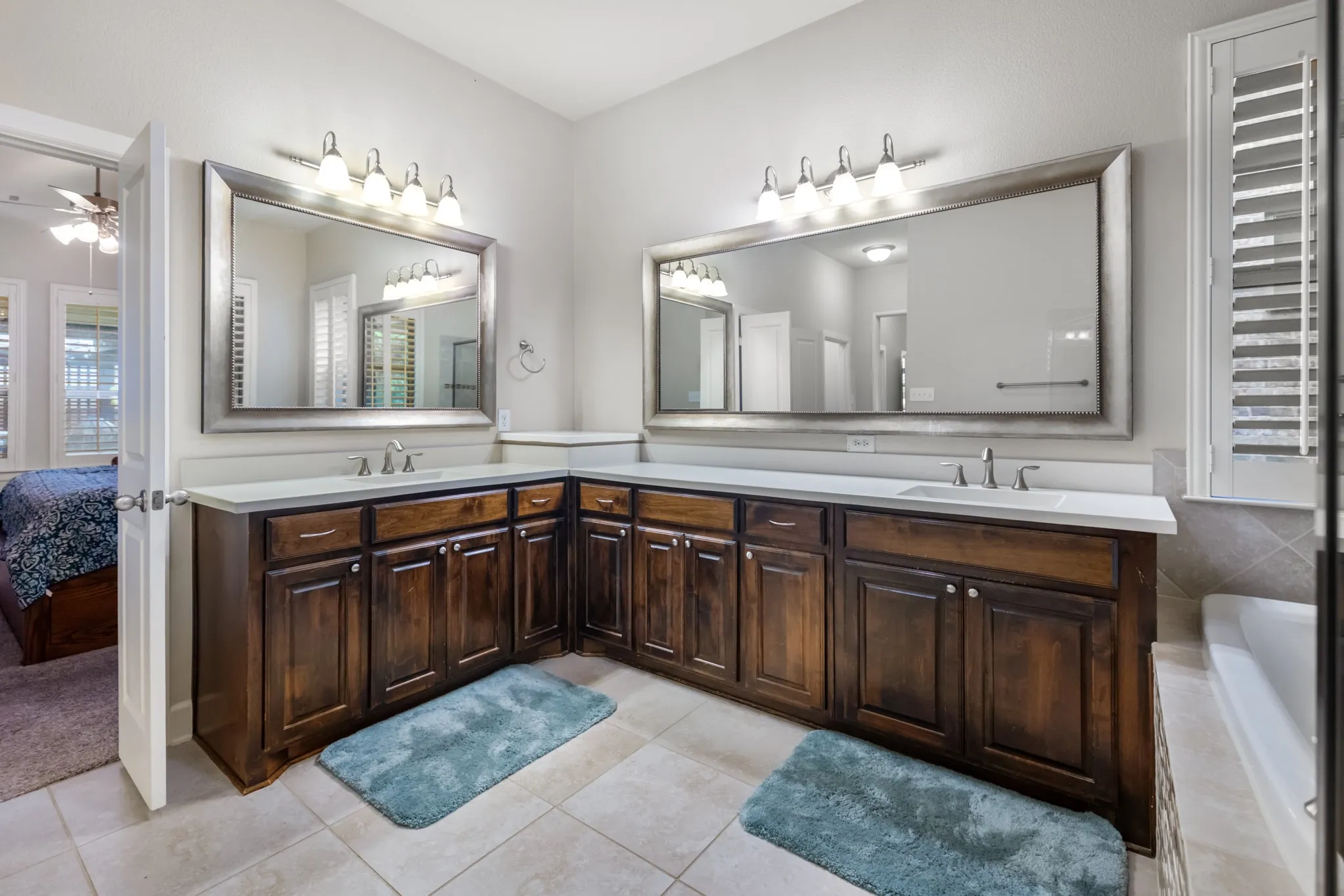Dual vanities featuring wood-finish cabinetry and light-toned countertops