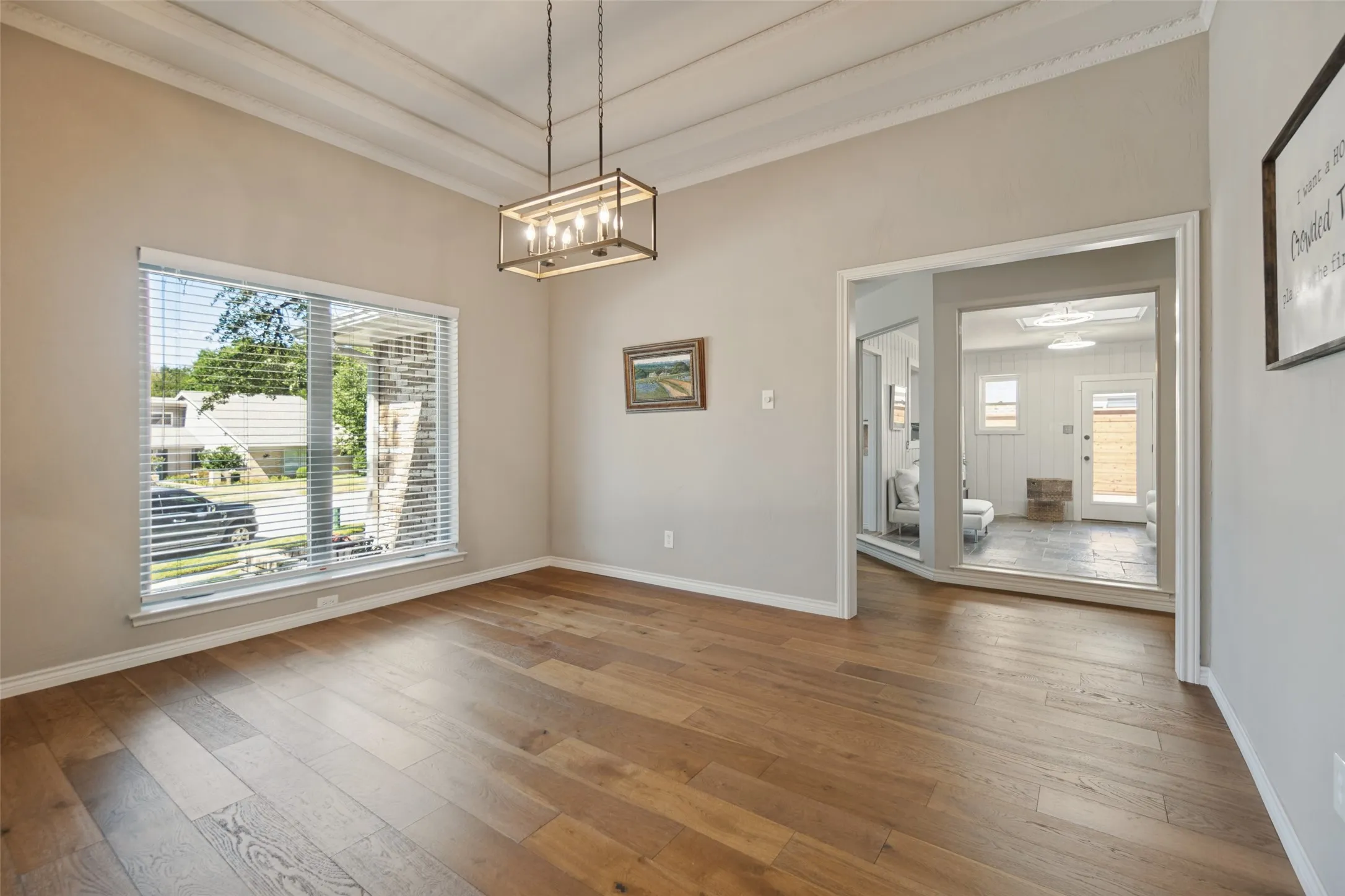 Wood-finish flooring, coffered ceiling, recessed lighting, and a large window with blinds