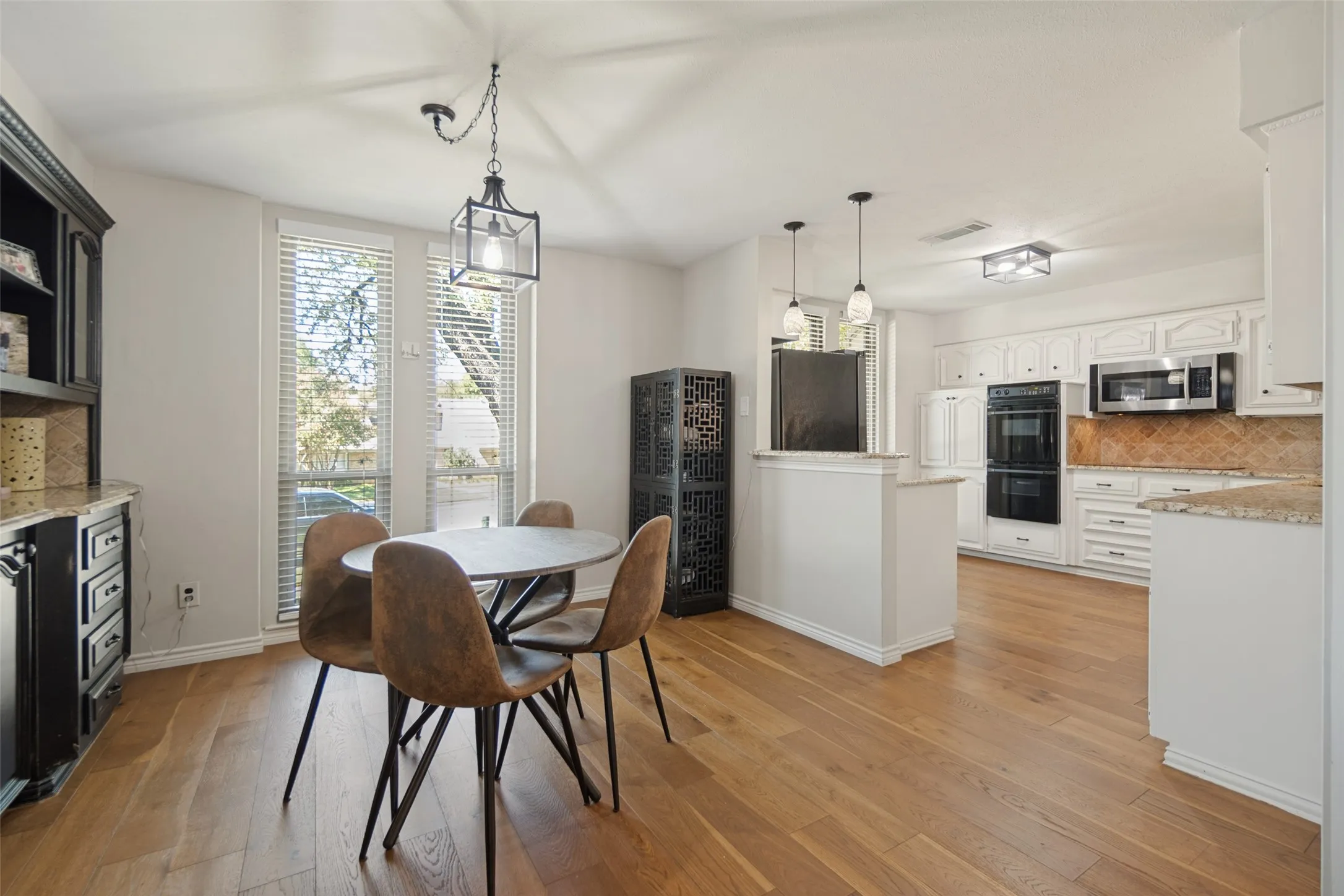 Wood-finish flooring throughout, with a built-in dark wood hutch featuring granite countertops