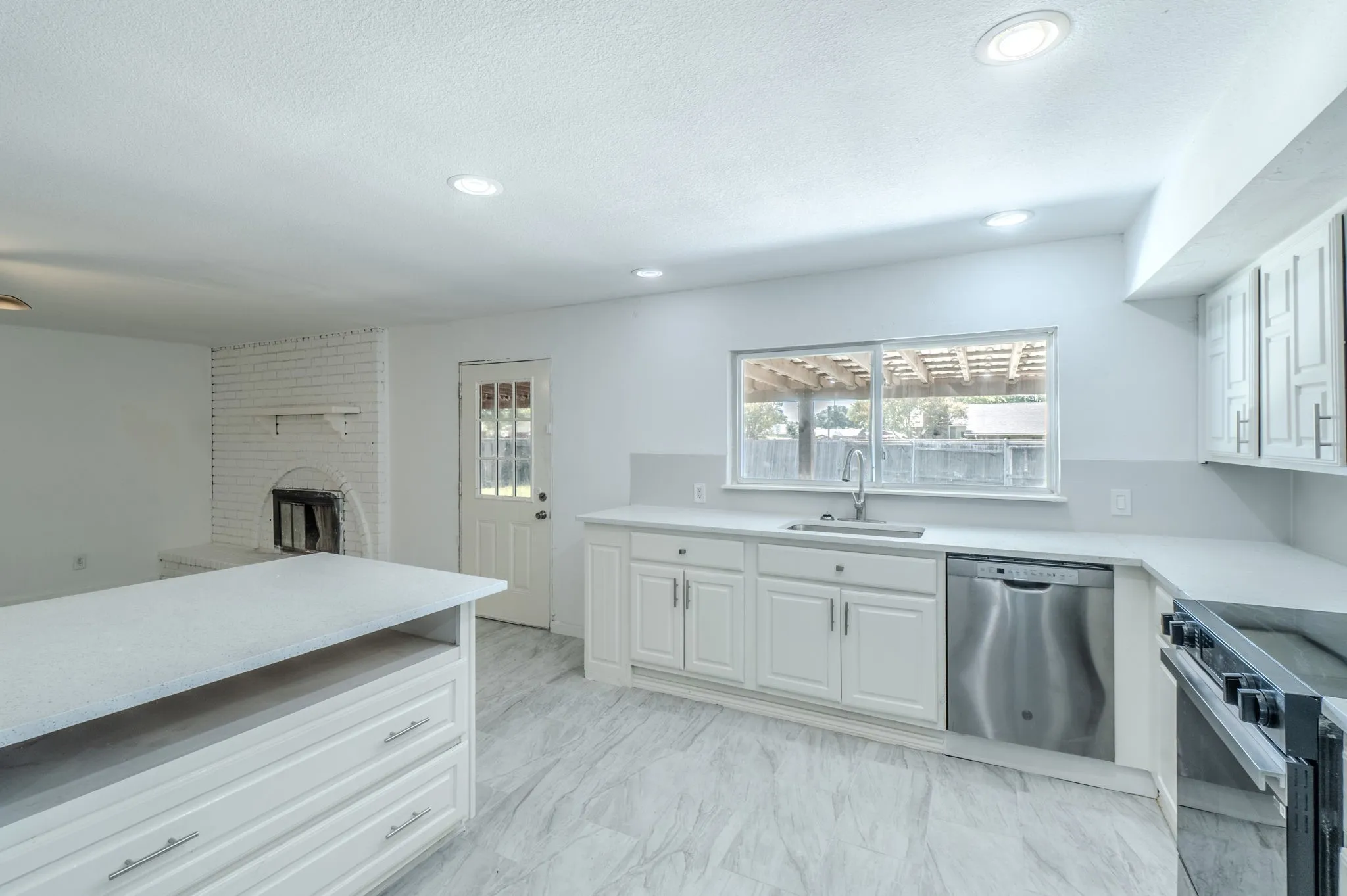 Recessed lighting, white shaker-style cabinetry, stainless steel dishwasher, white countertops, and wood-finish flooring