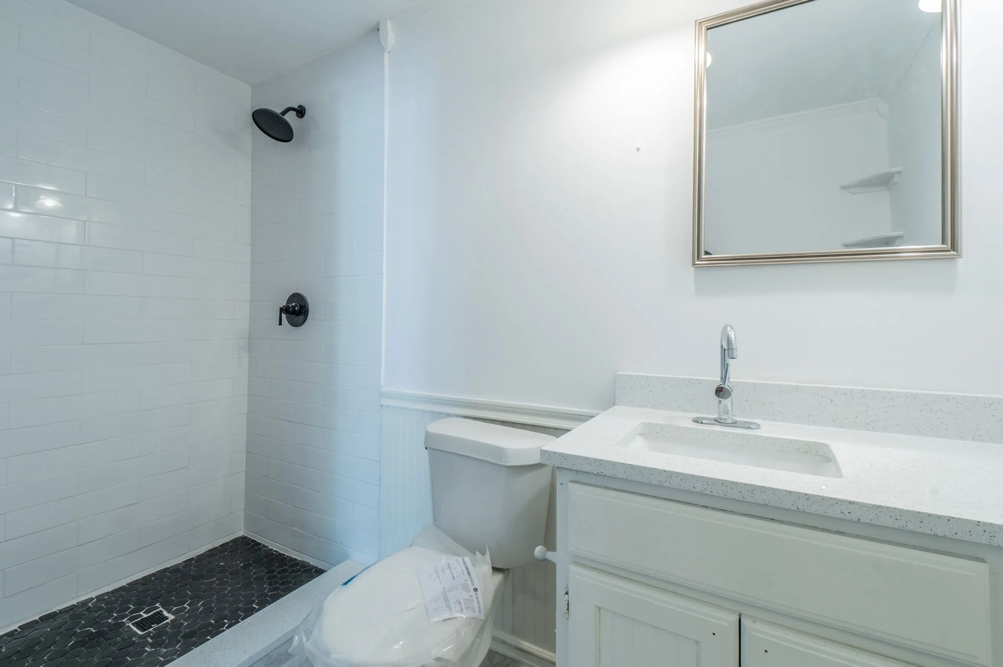 White subway tile shower surround with black fixtures