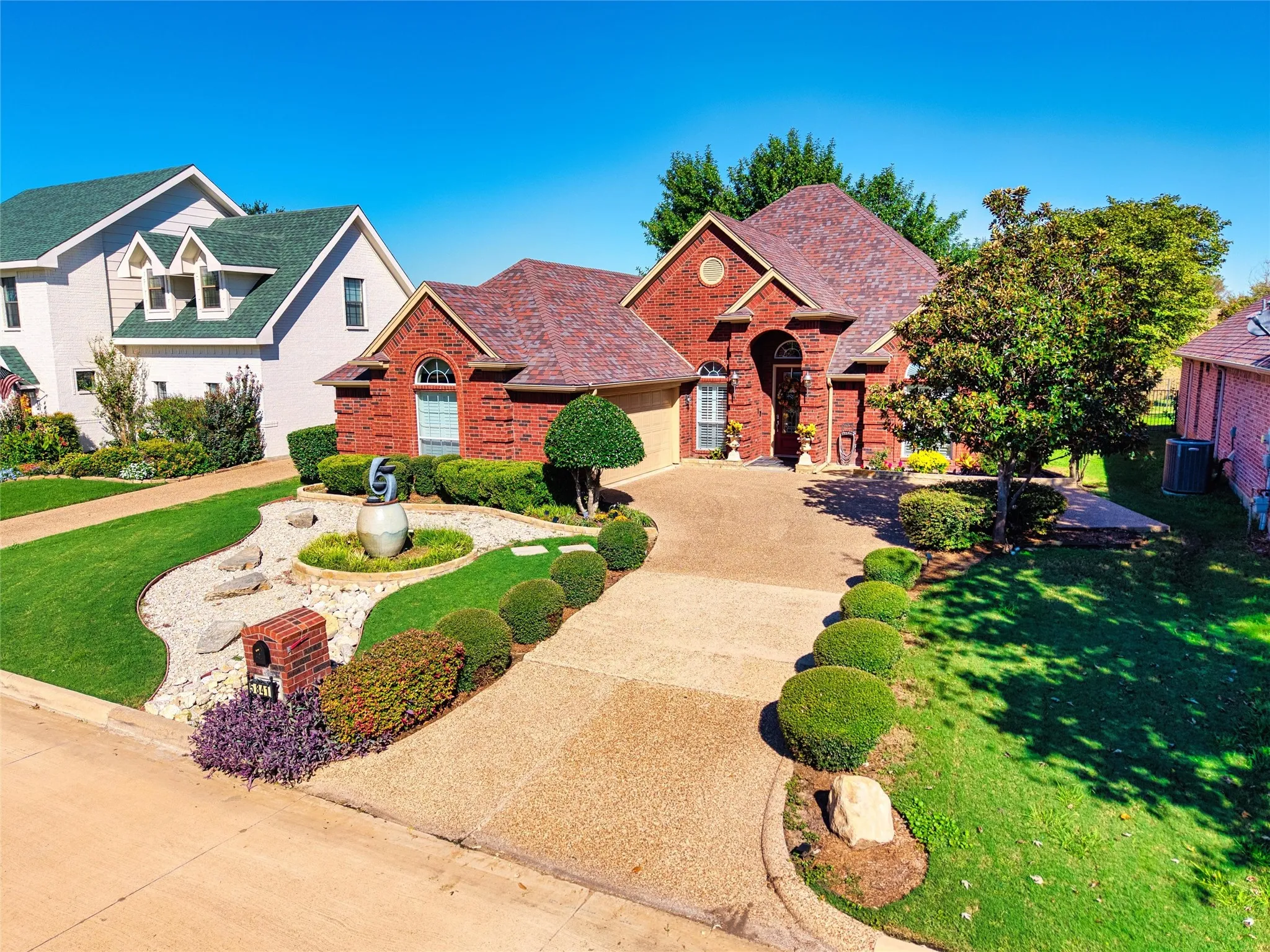 Brick exterior with an arched entryway, gabled roof, and attached 2 car garage