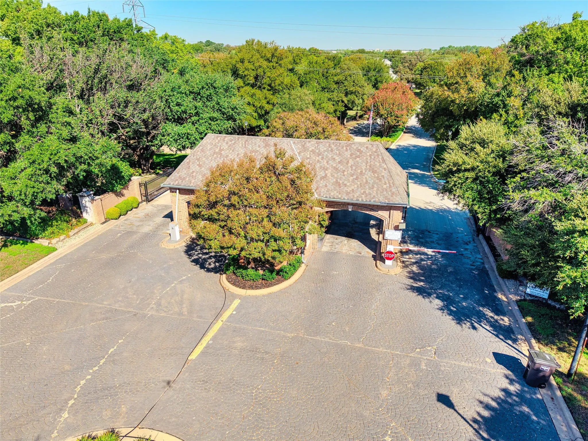 24 Hr Security gated community entry with a brick and shingle-roofed archway