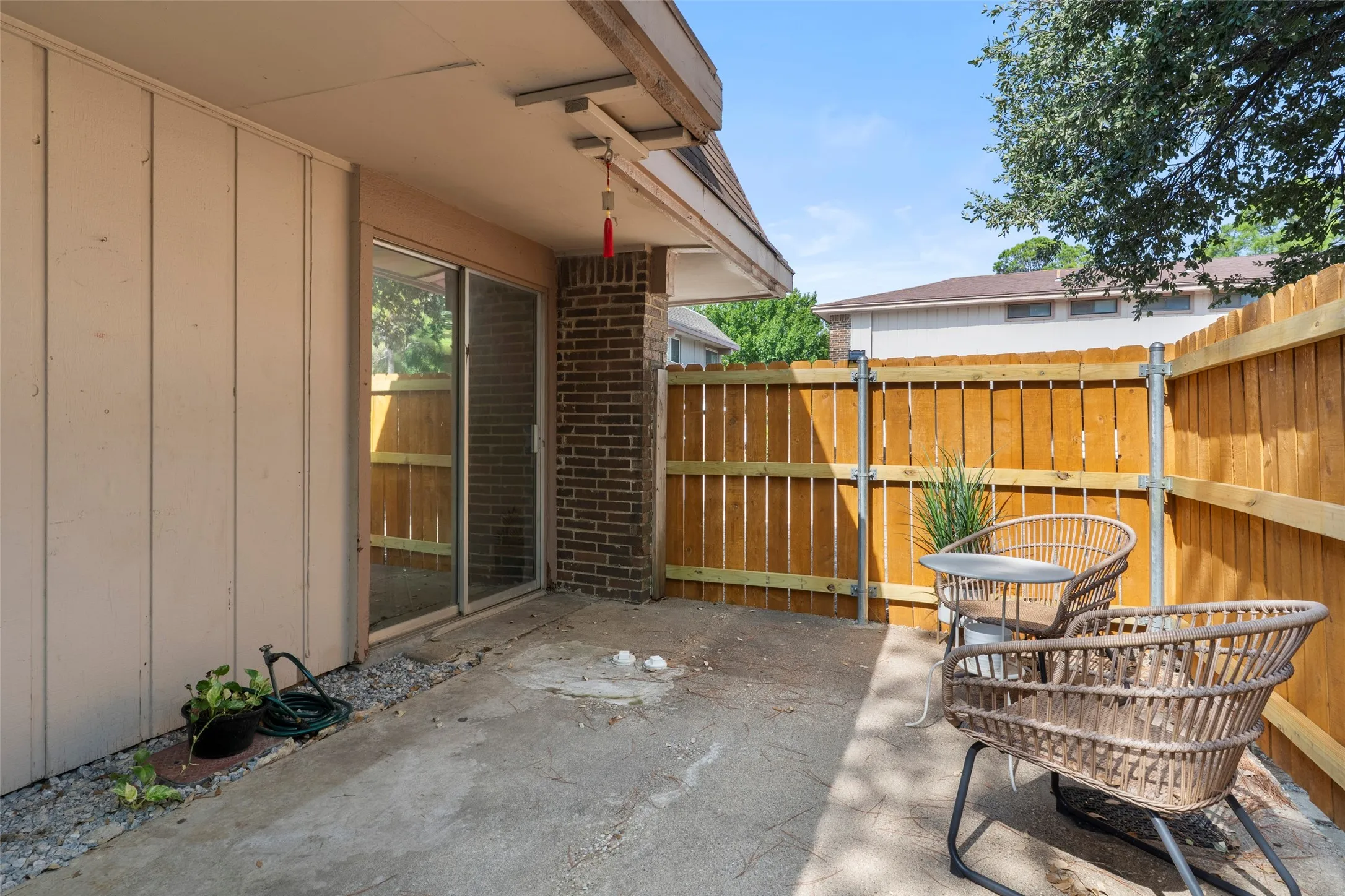 Covered patio with concrete flooring and wood-finish fence enclosure