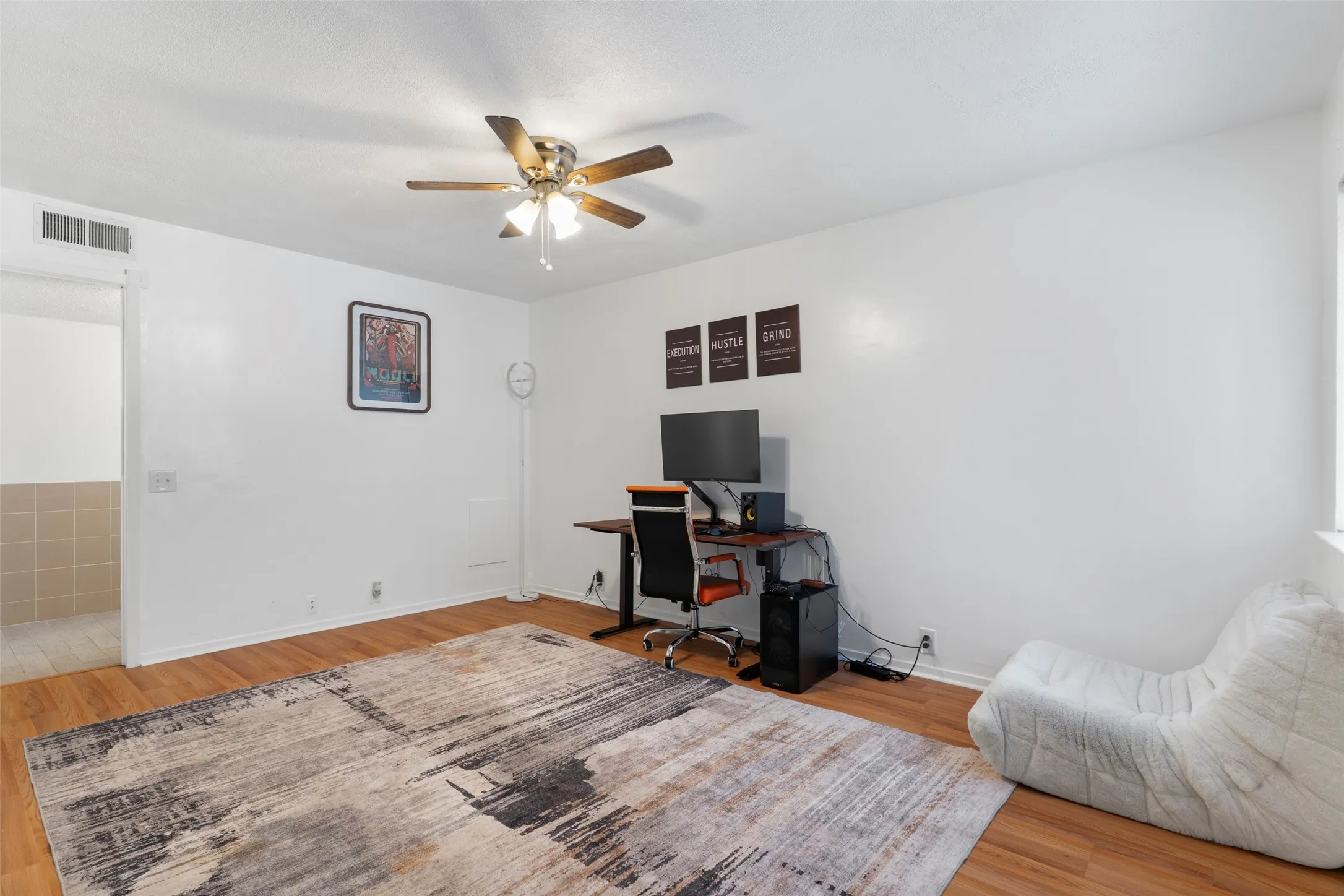 Wood-finish flooring with a ceiling fan overhead