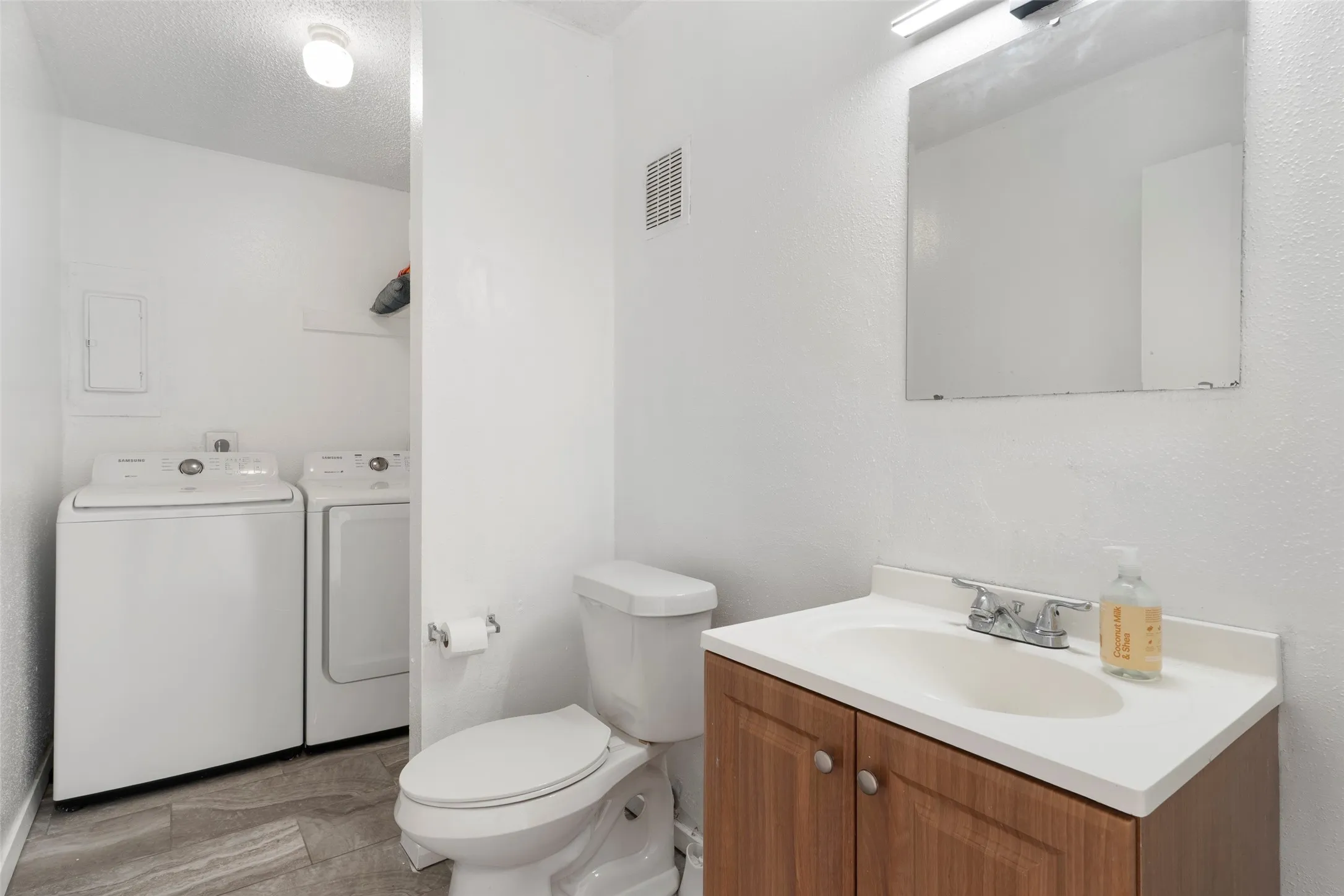 Wood-finish vanity with a white countertop and integrated sink
