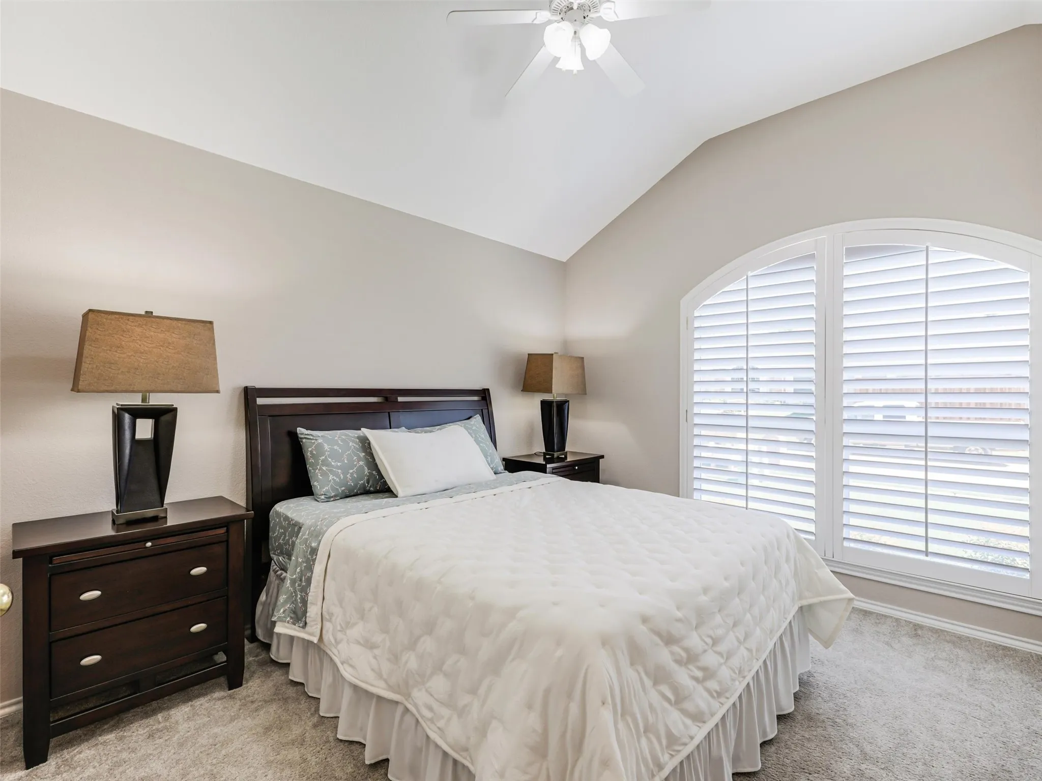 Guest bedroom has plantation shutter and walk-in closet