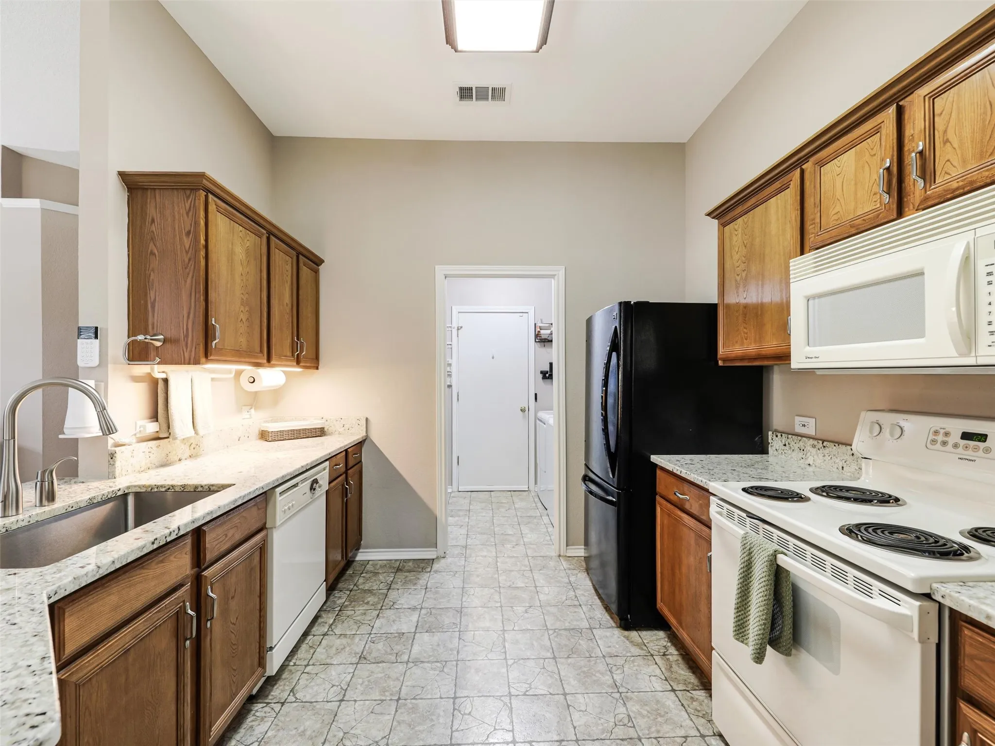 Kitchen offer granite counters and deep stainless sink