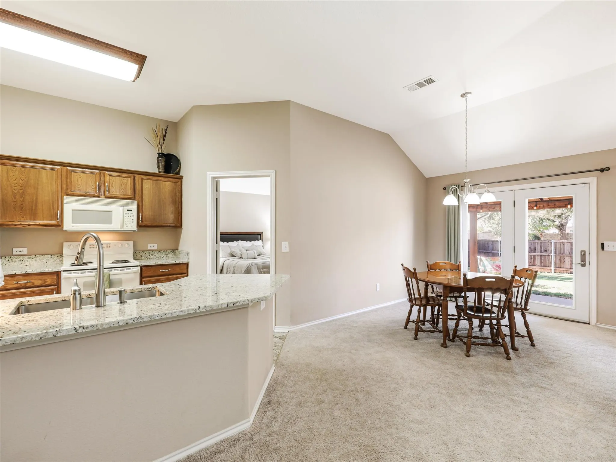 Granite counters set off this charming kitchen with oversized stainless sink