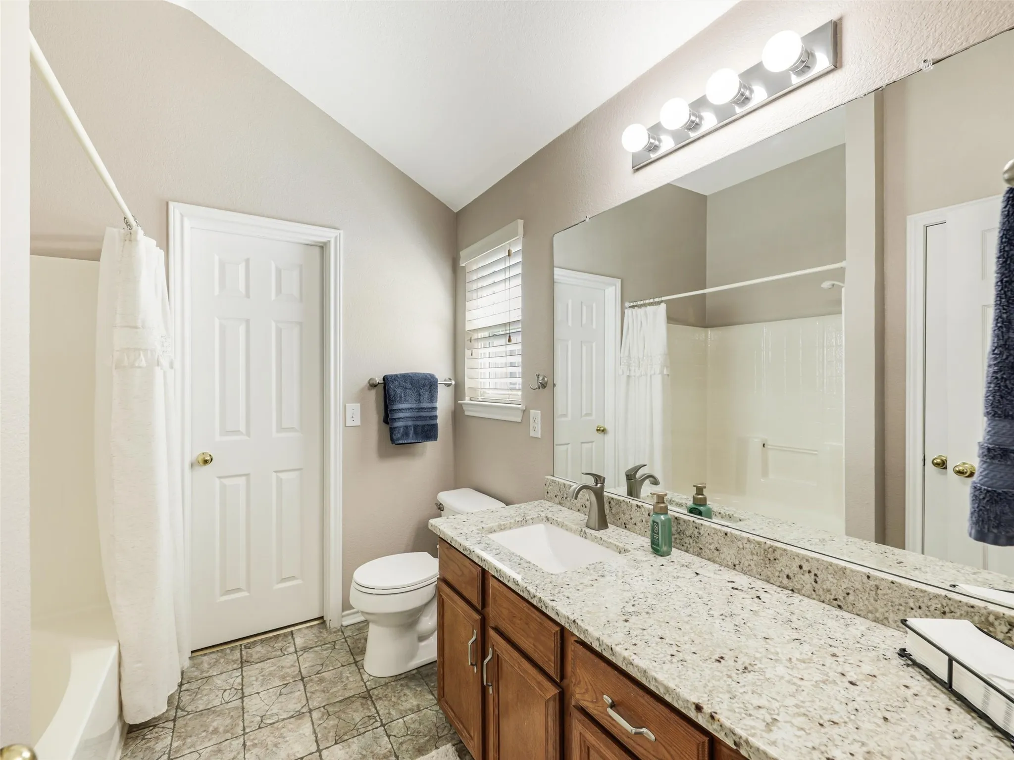 Primary bath features soaking tub with shower head and granite counters