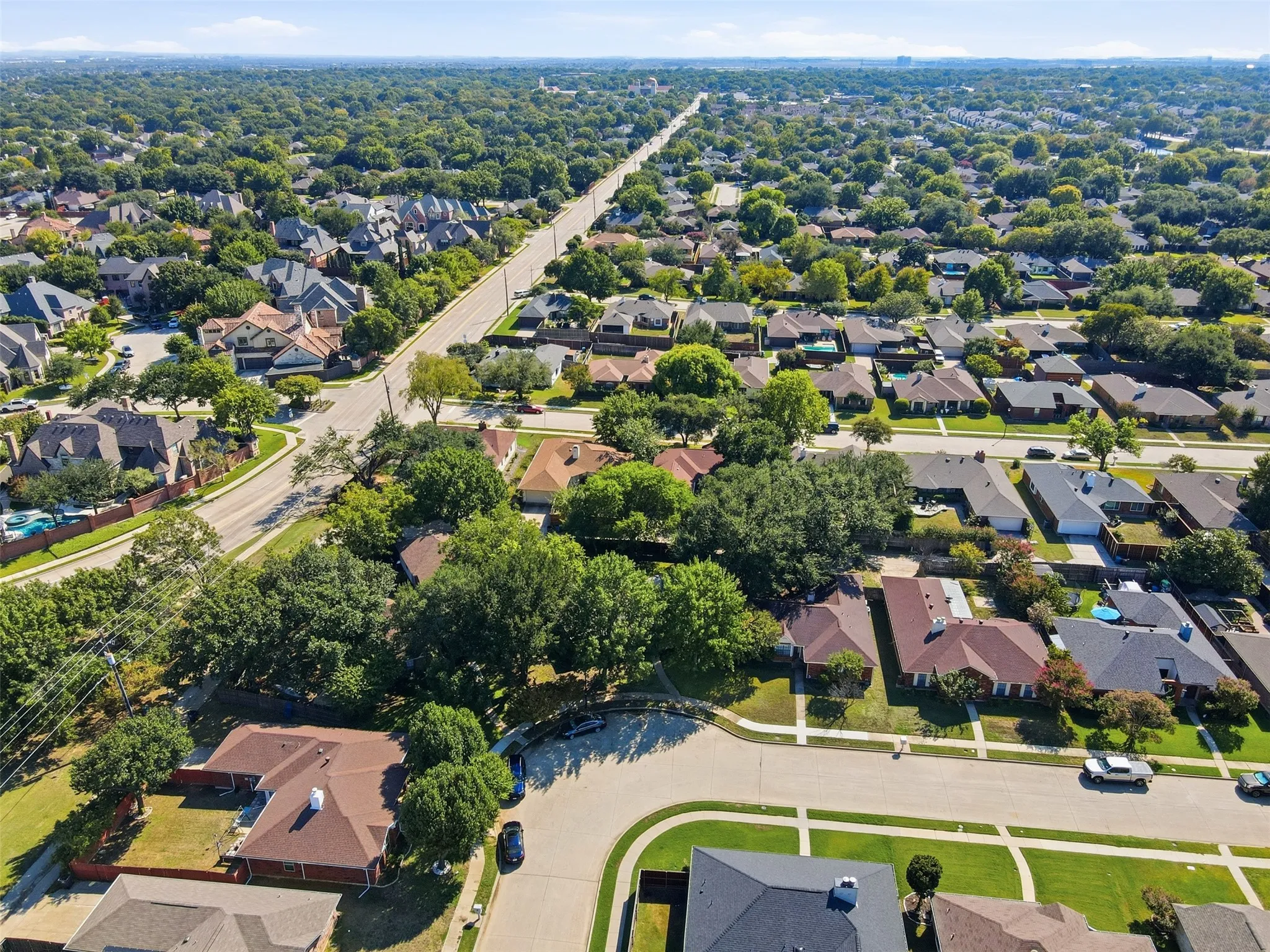 Aerial perspective of this established residential community featuring tree-lined streets, spacious corner lot positioning, and mature landscaping throughout the neighborhood