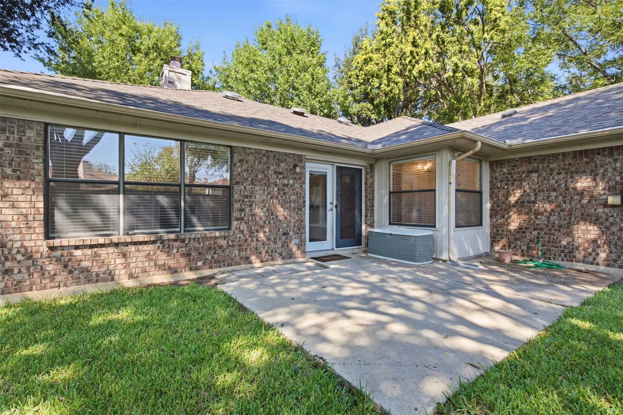 Brick exterior construction with an expansive concrete patio and large windows