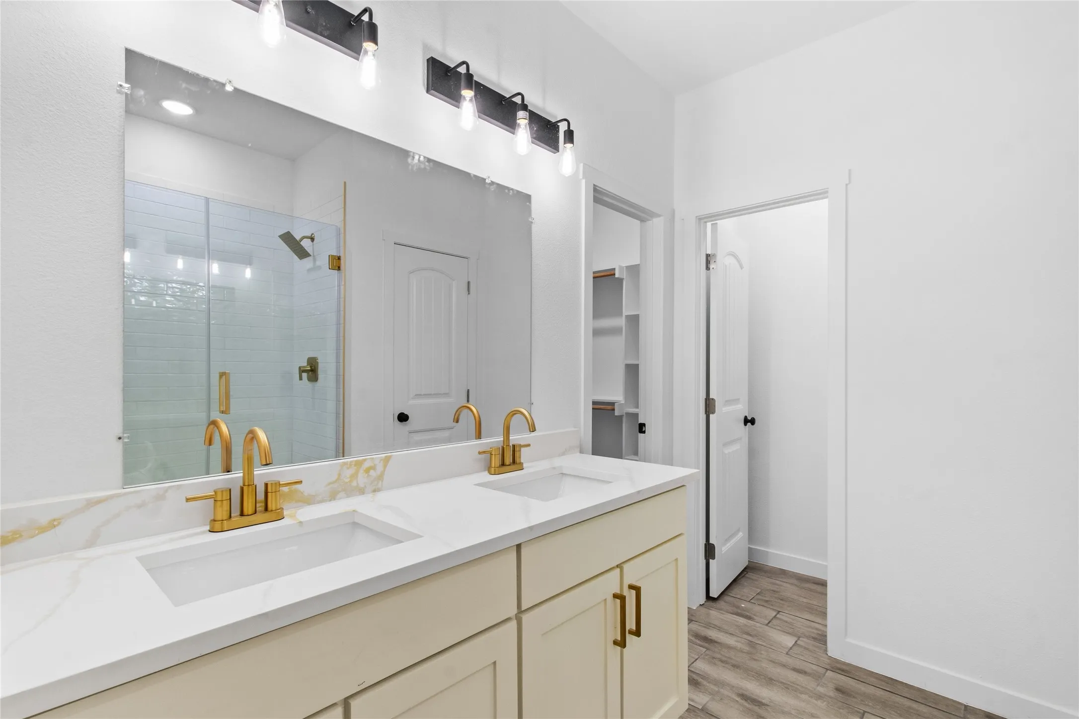 Dual vanity with gold-tone fixtures and integrated sinks, complemented by a quartz-finish countertop