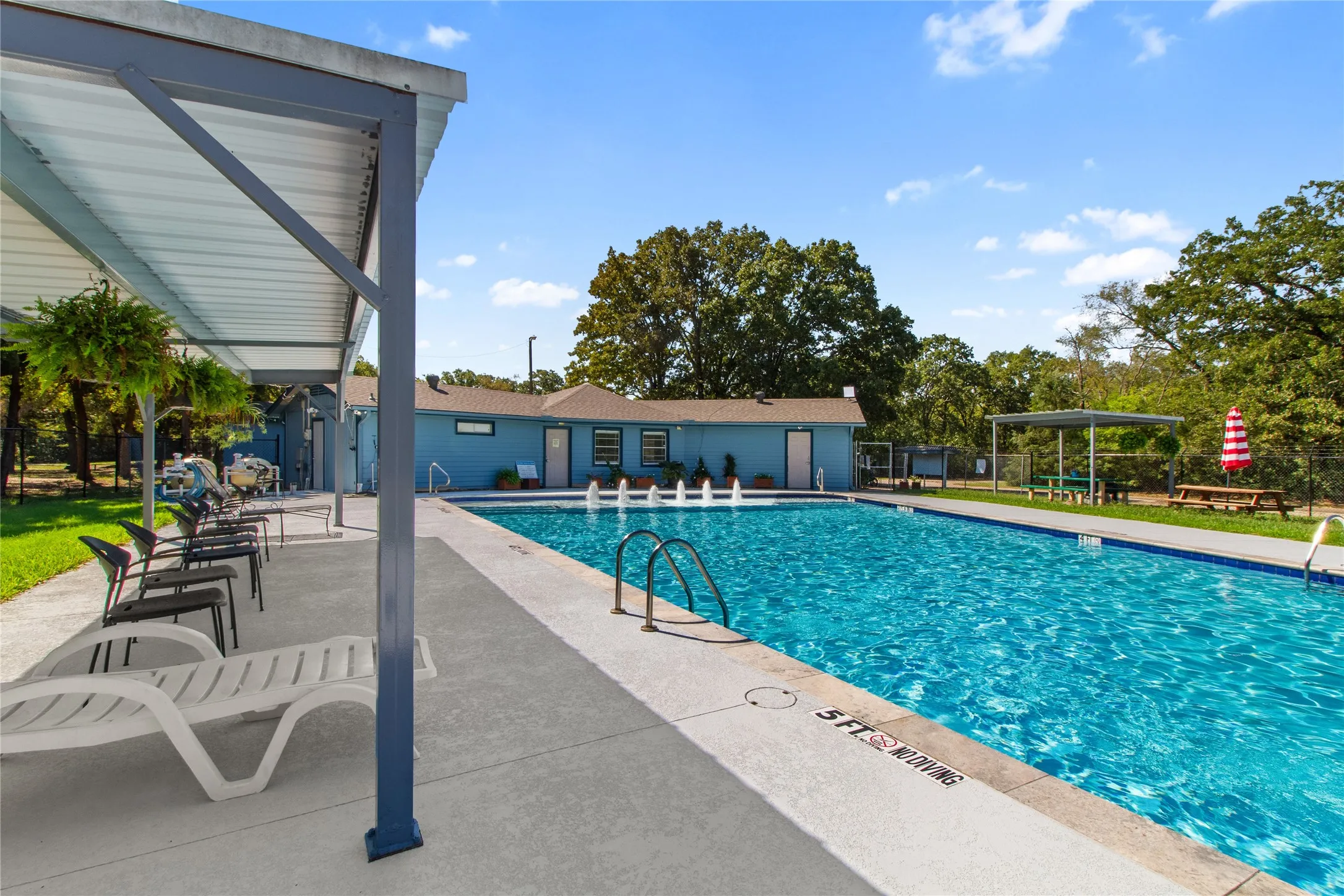 Swimming pool with integrated fountains, surrounded by a concrete deck