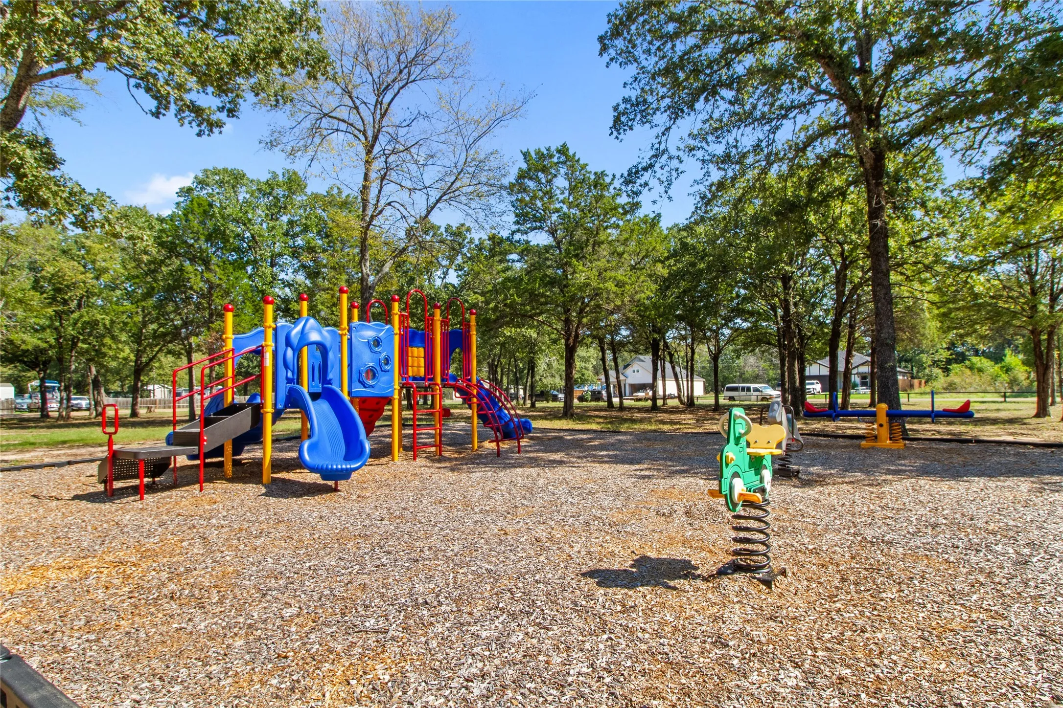 Outdoor playground featuring a multi-level play structure, slides, and a spring rider