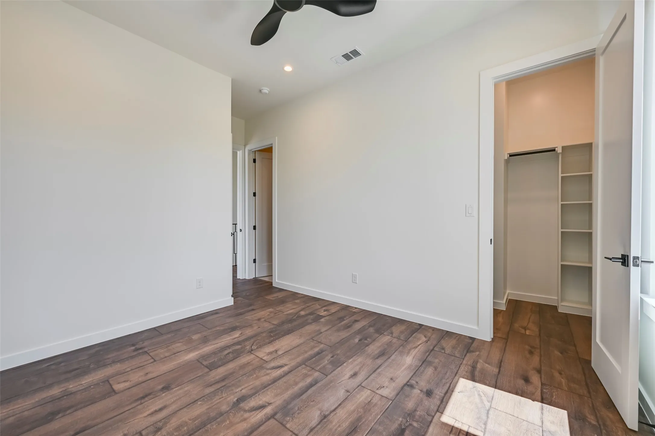 Wood-finish flooring, recessed lighting, and a ceiling fan