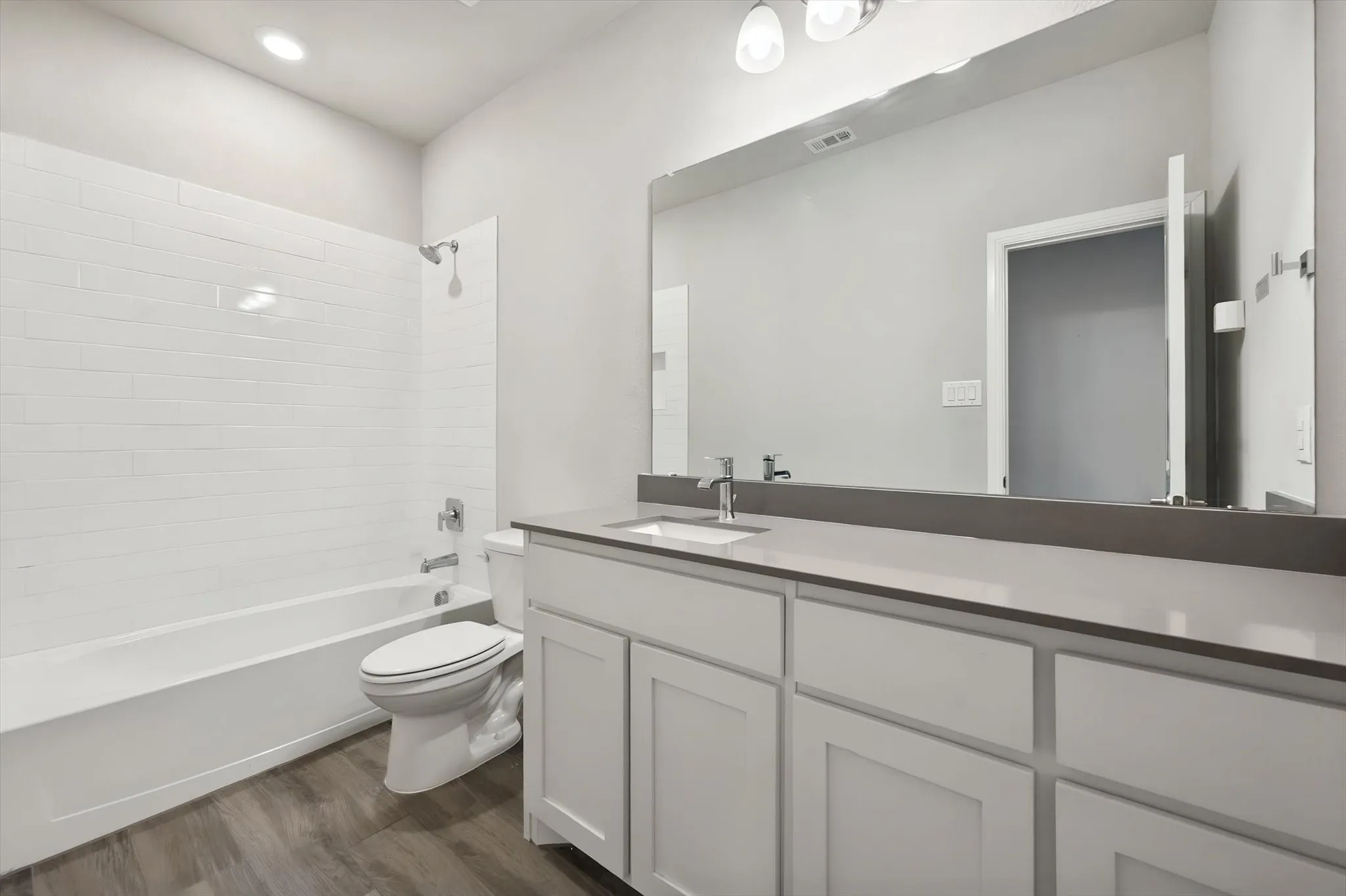 Full bath with white subway tile shower and quartz countertops