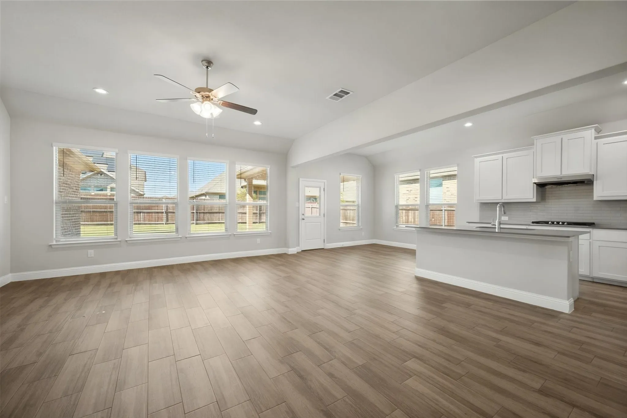 Open-concept living space featuring wood-finish flooring, recessed lighting, and a ceiling fan