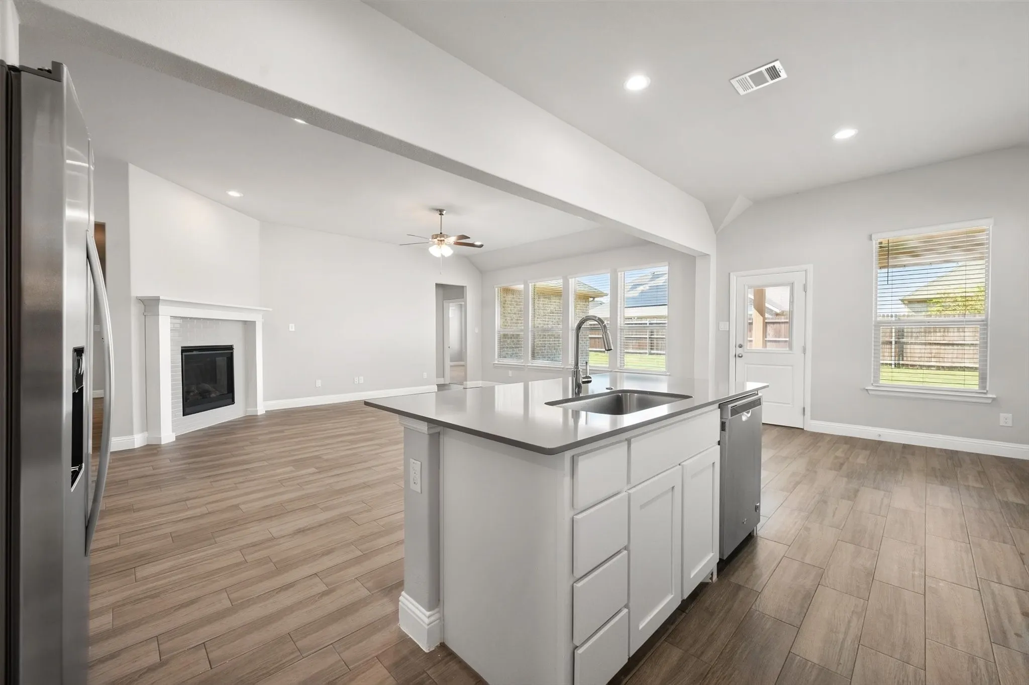 Large Kitchen island with an undermount sink, a stainless steel faucet, and a built-in dishwasher