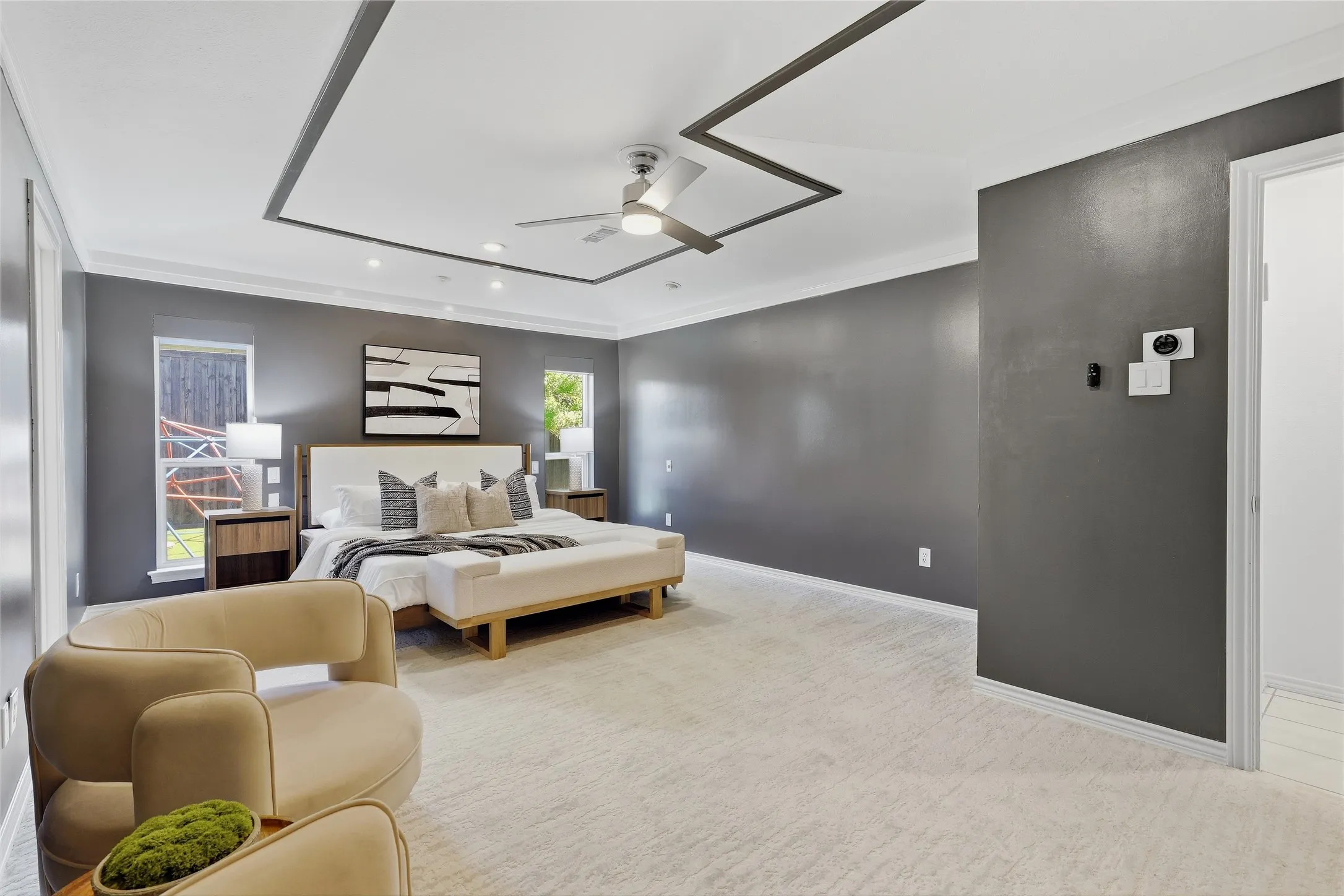 Tray ceiling with accent trim, recessed lighting, ceiling fan, and carpeted flooring