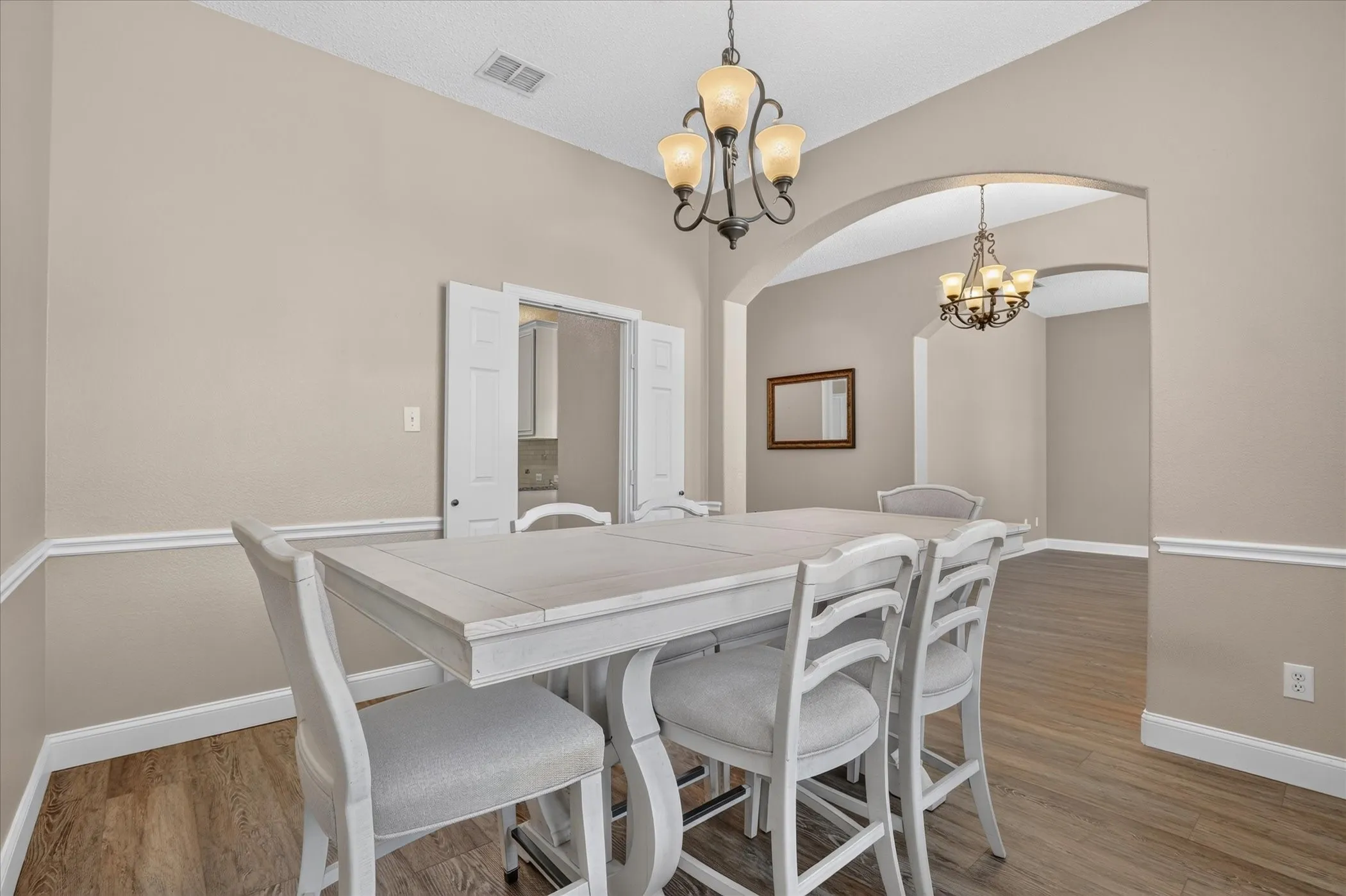 Wood-finish flooring throughout, complemented by chair rail molding and arched doorways