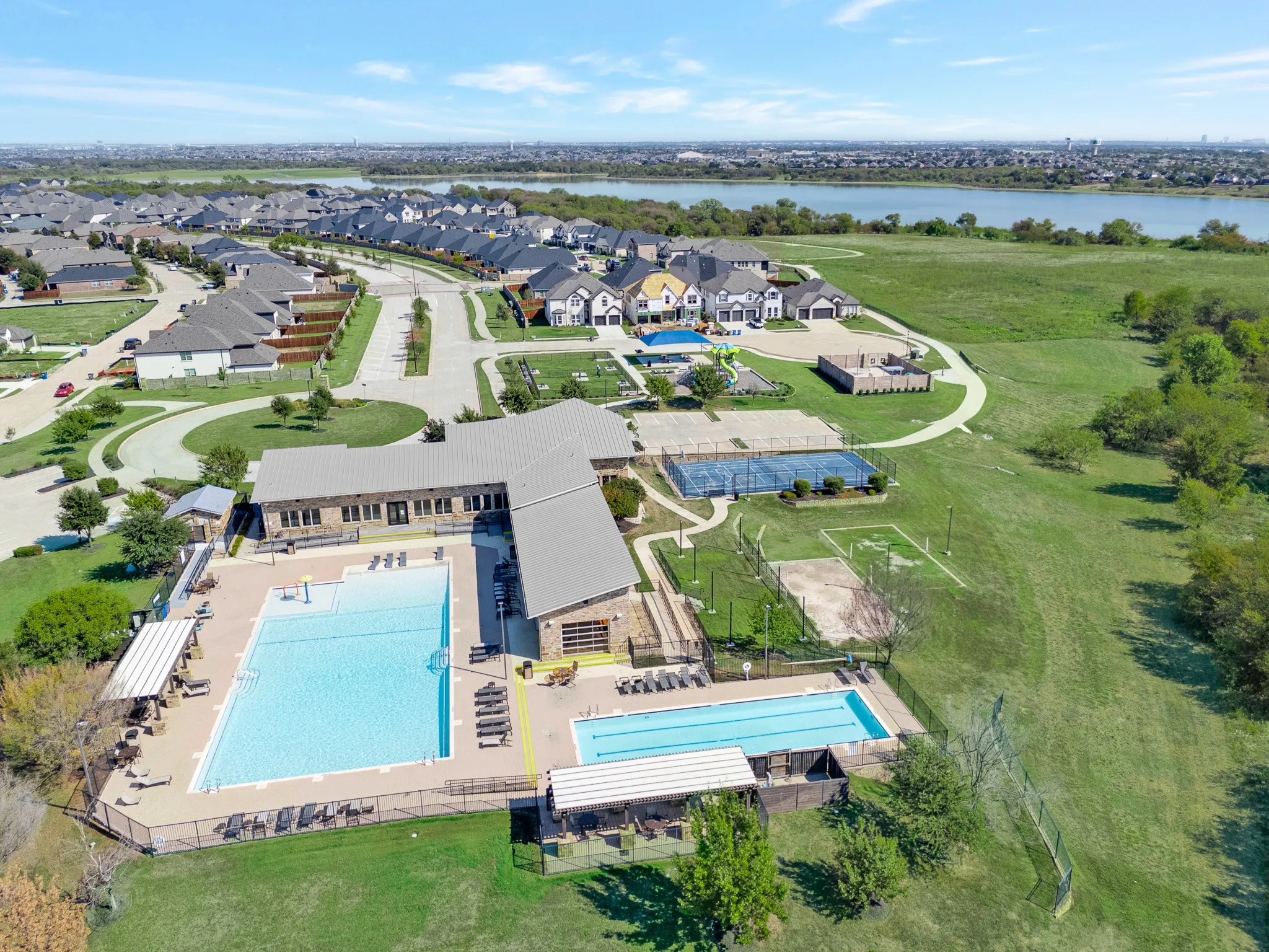 Community amenities featuring multiple swimming pools, sports courts, a playground, and expansive green spaces