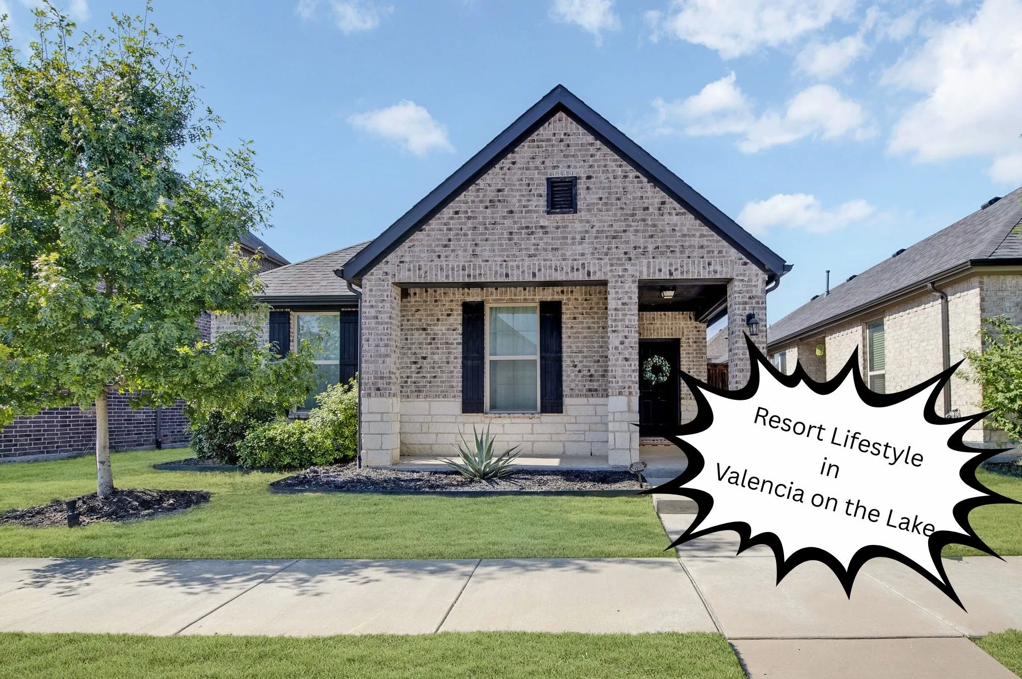 Brick and stone facade, covered entry, gabled roofline, front-facing window with shutters, established landscaping