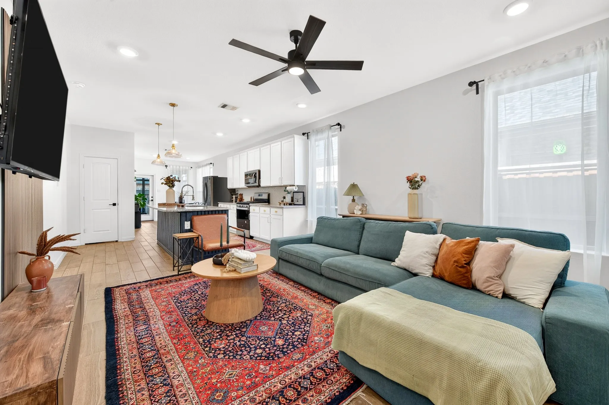 Open-concept living space featuring wood-finish flooring, recessed lighting, and a ceiling fan