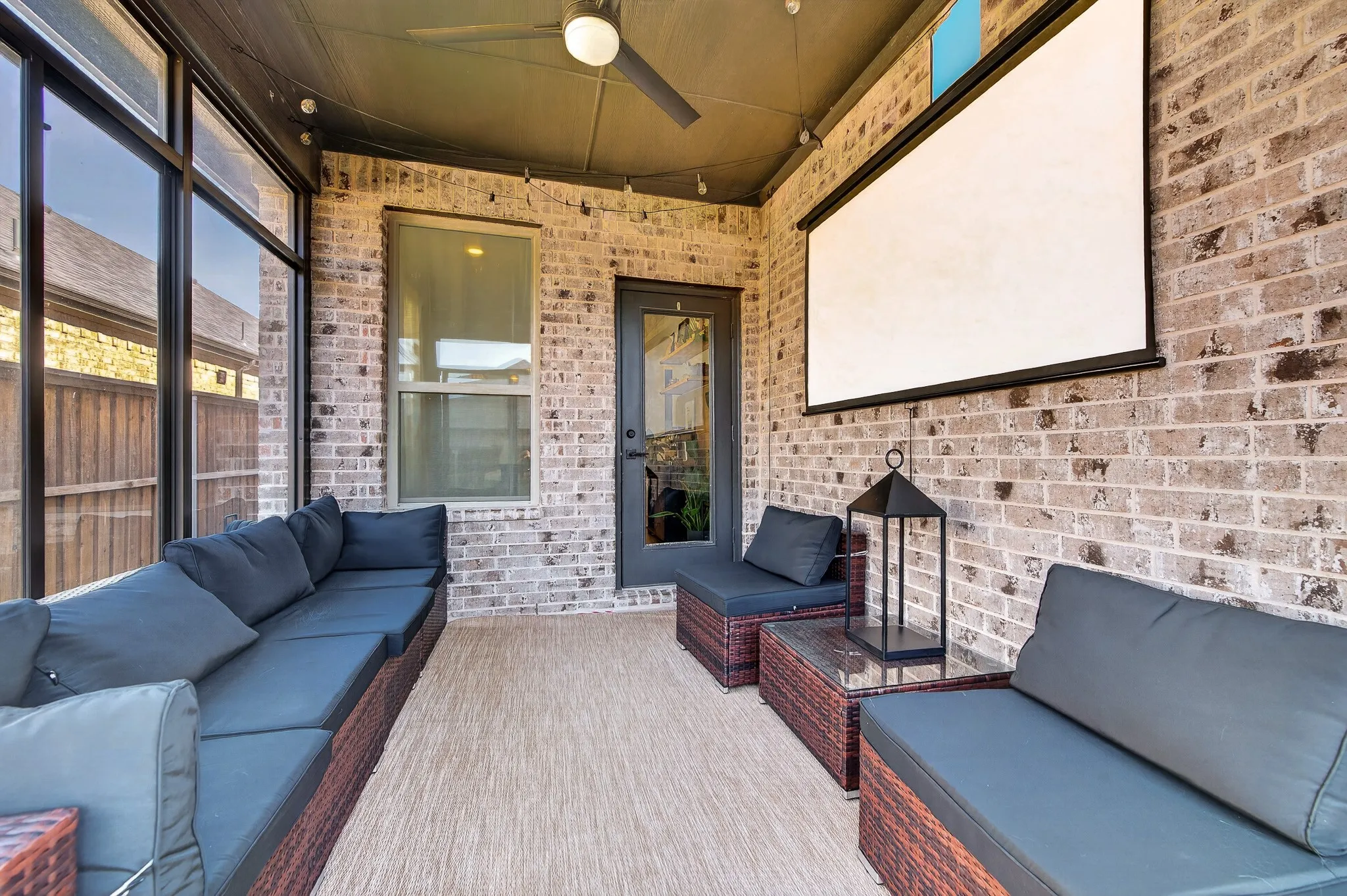 Covered porch with exposed brick walls, wood-finish flooring, and built-in seating along brick planters