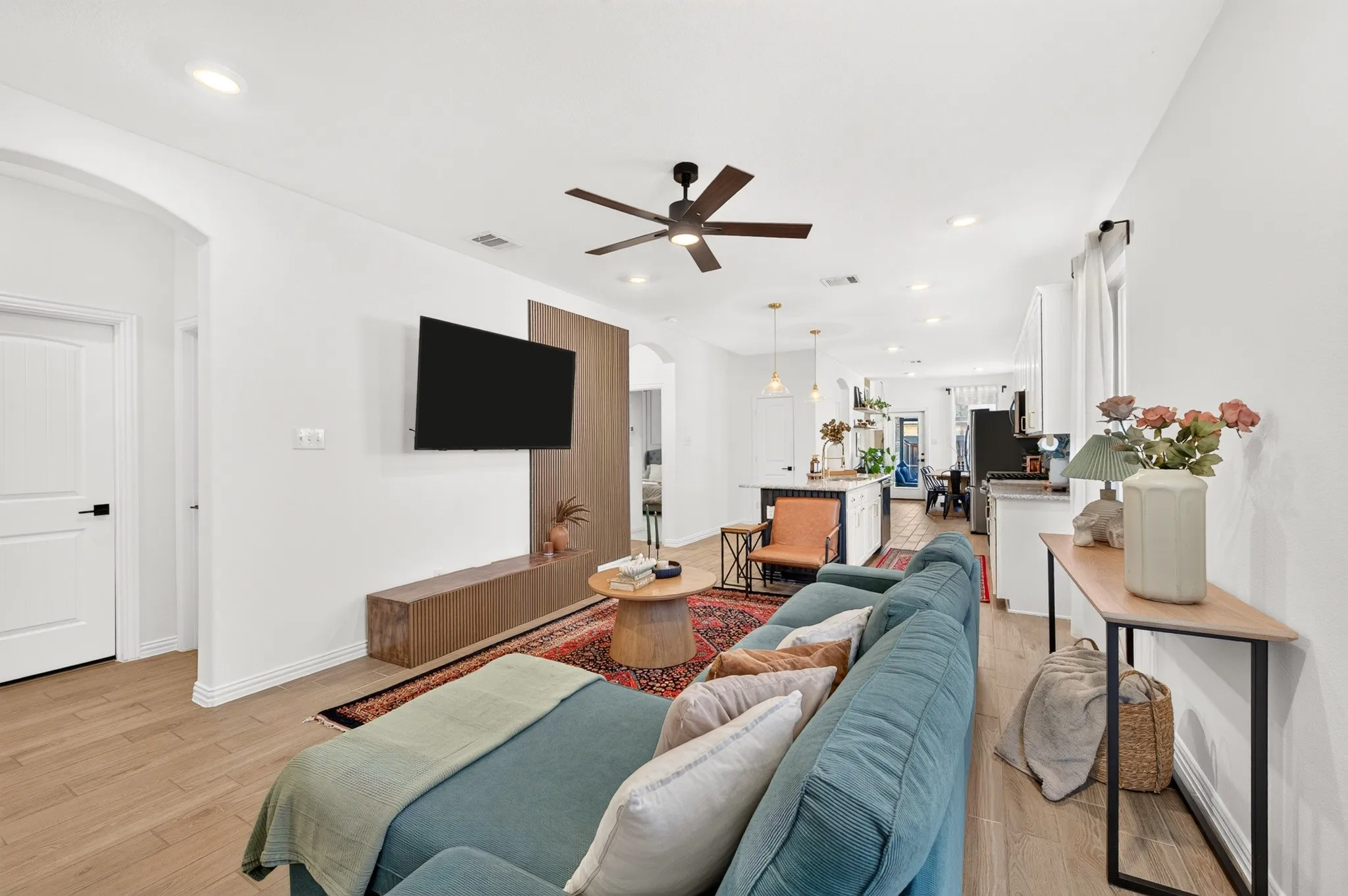 Open-concept living area featuring wood-finish flooring, recessed lighting, and a ceiling fan