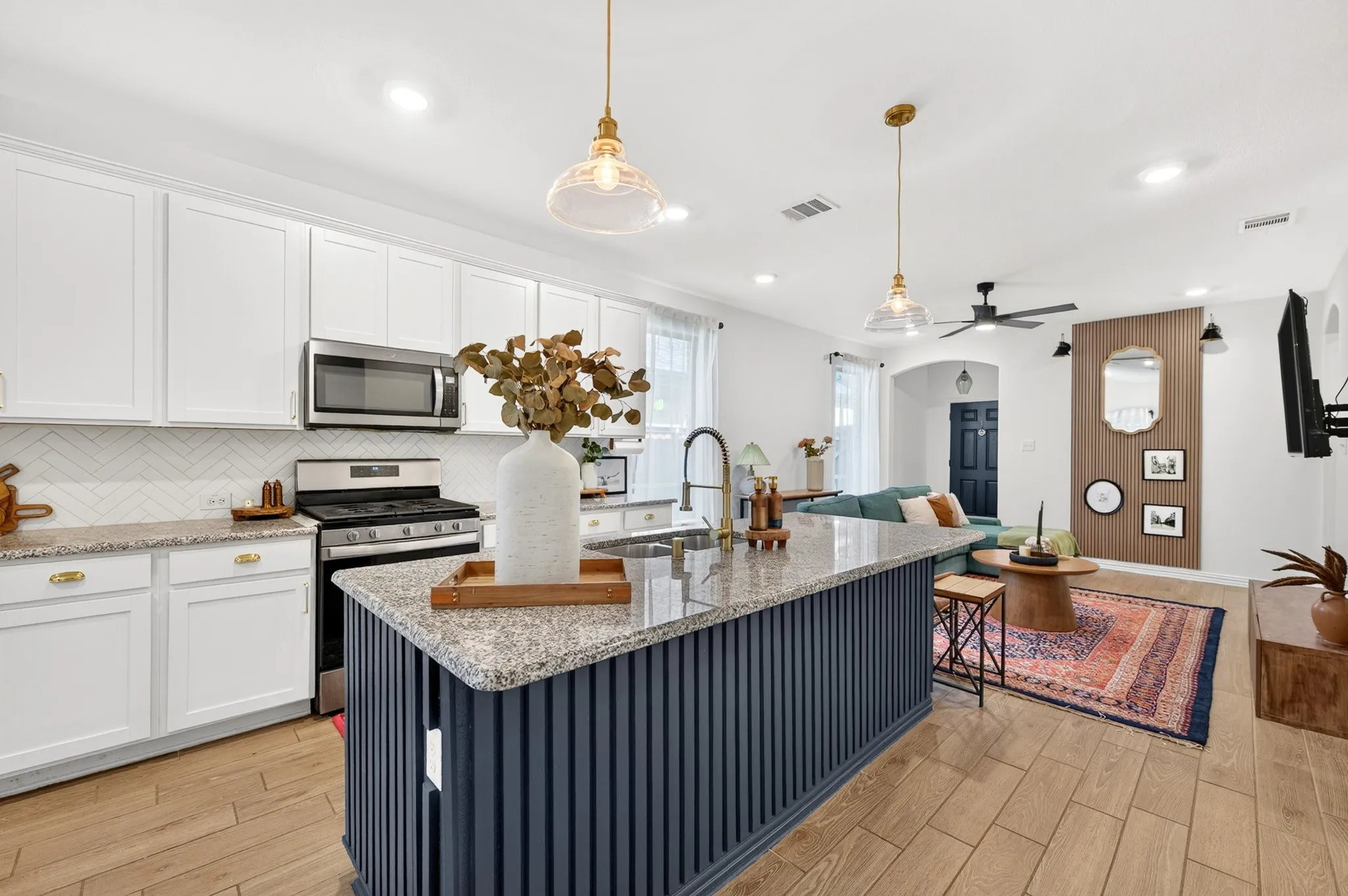 Modern kitchen featuring white cabinetry, granite countertops, and stainless steel appliances